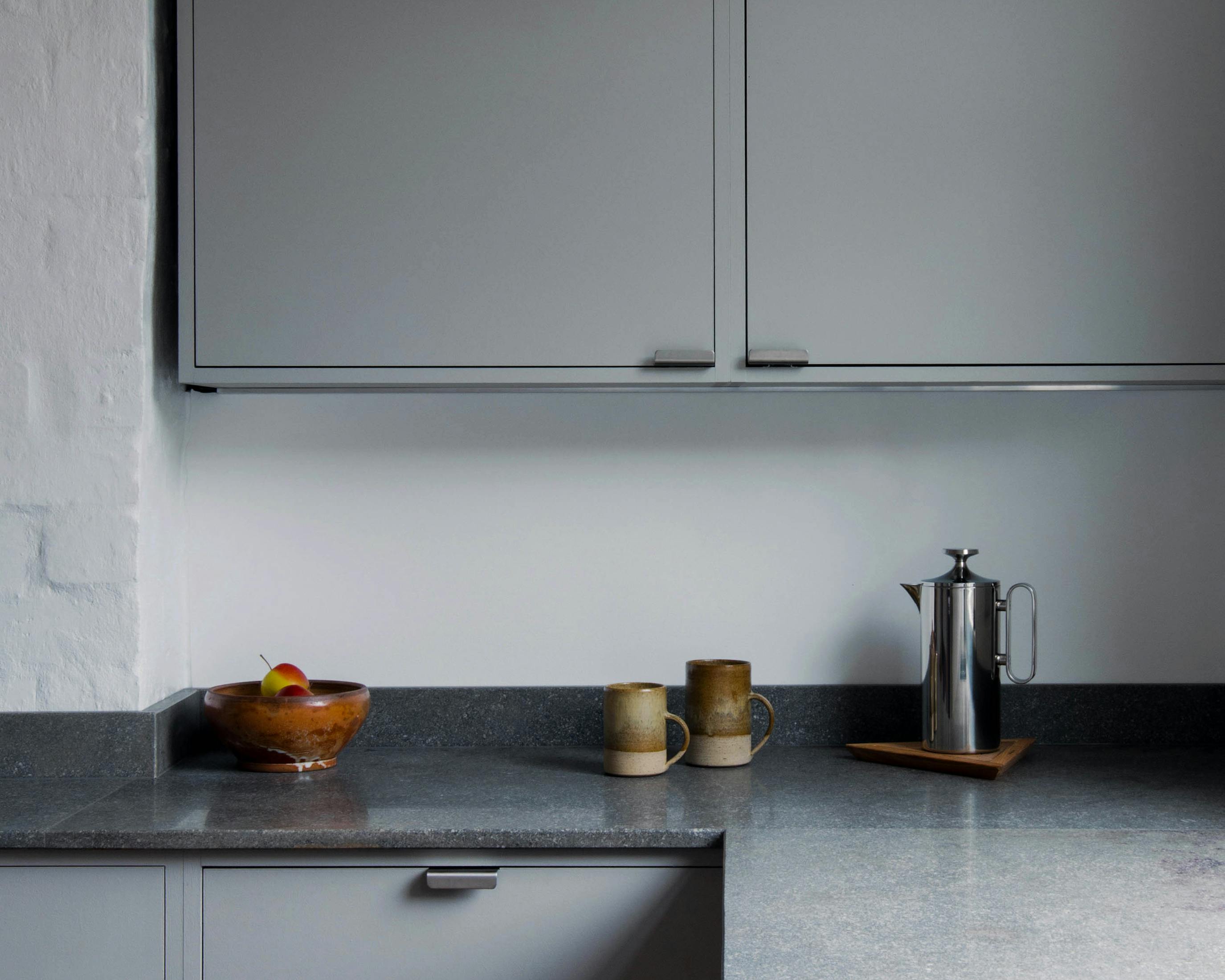 Minimal warm grey painted Ma-kon kitchen with limestone worktops.
