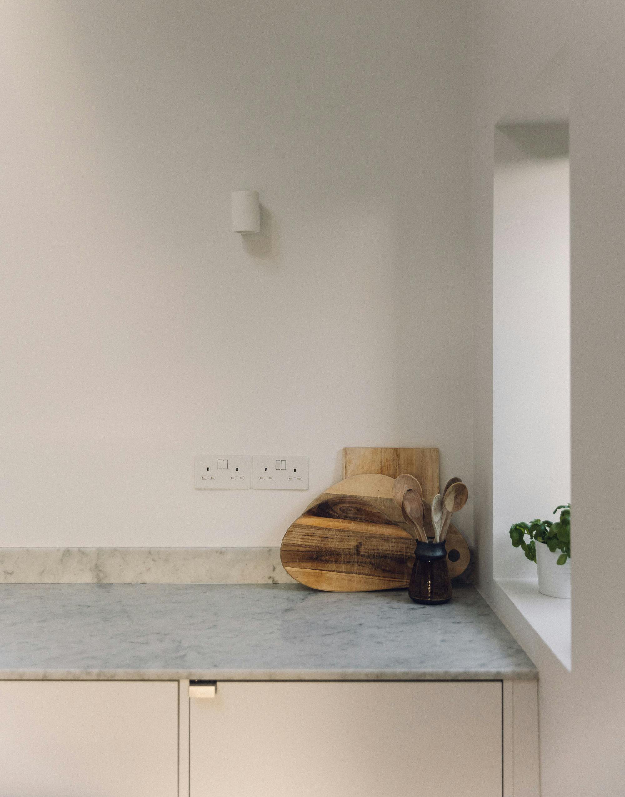 Minimal white painted Ma-kon kitchen with Carrara marble worktop.