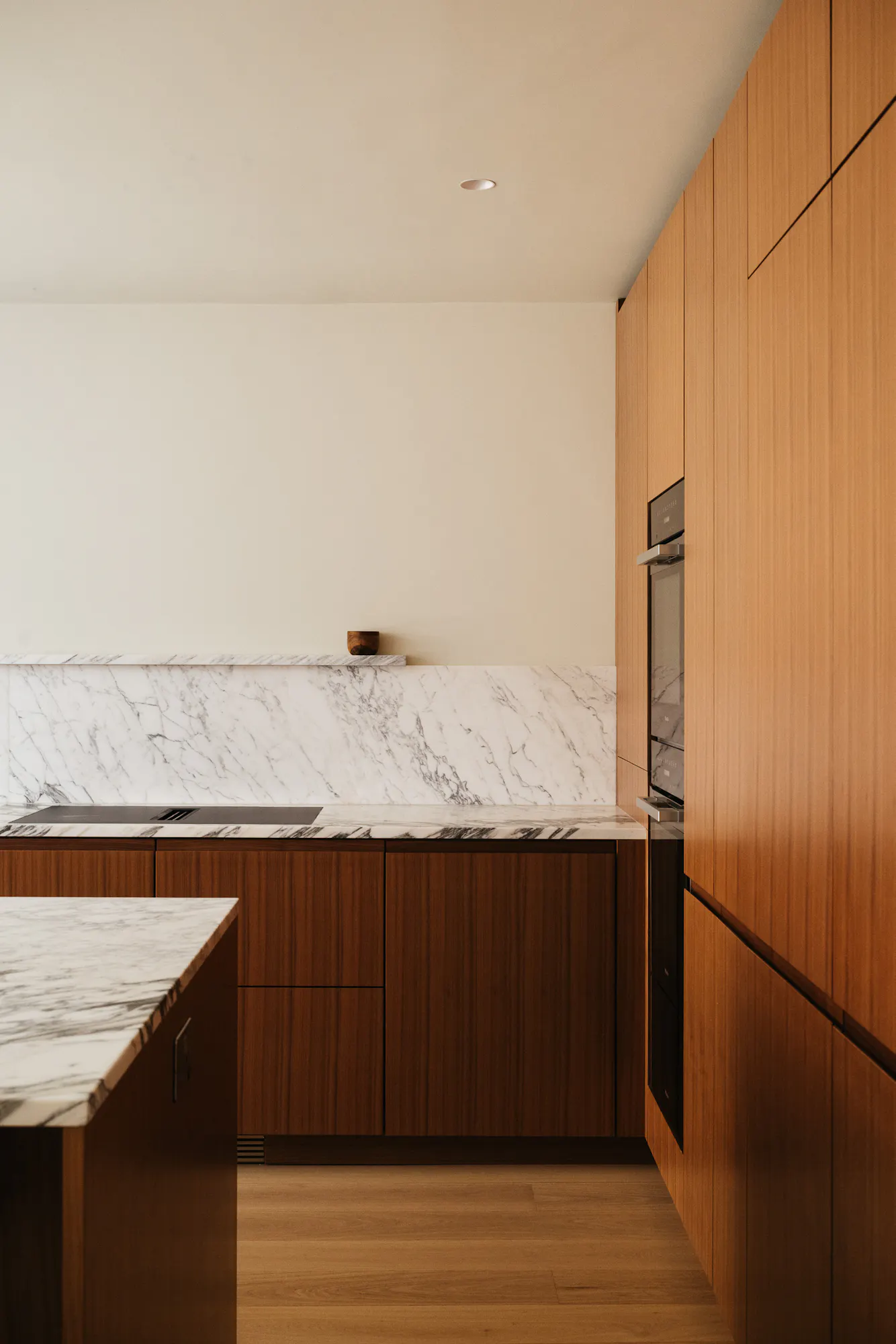 Contemporary walnut timber and arabescato marble Ma-kon kitchen.