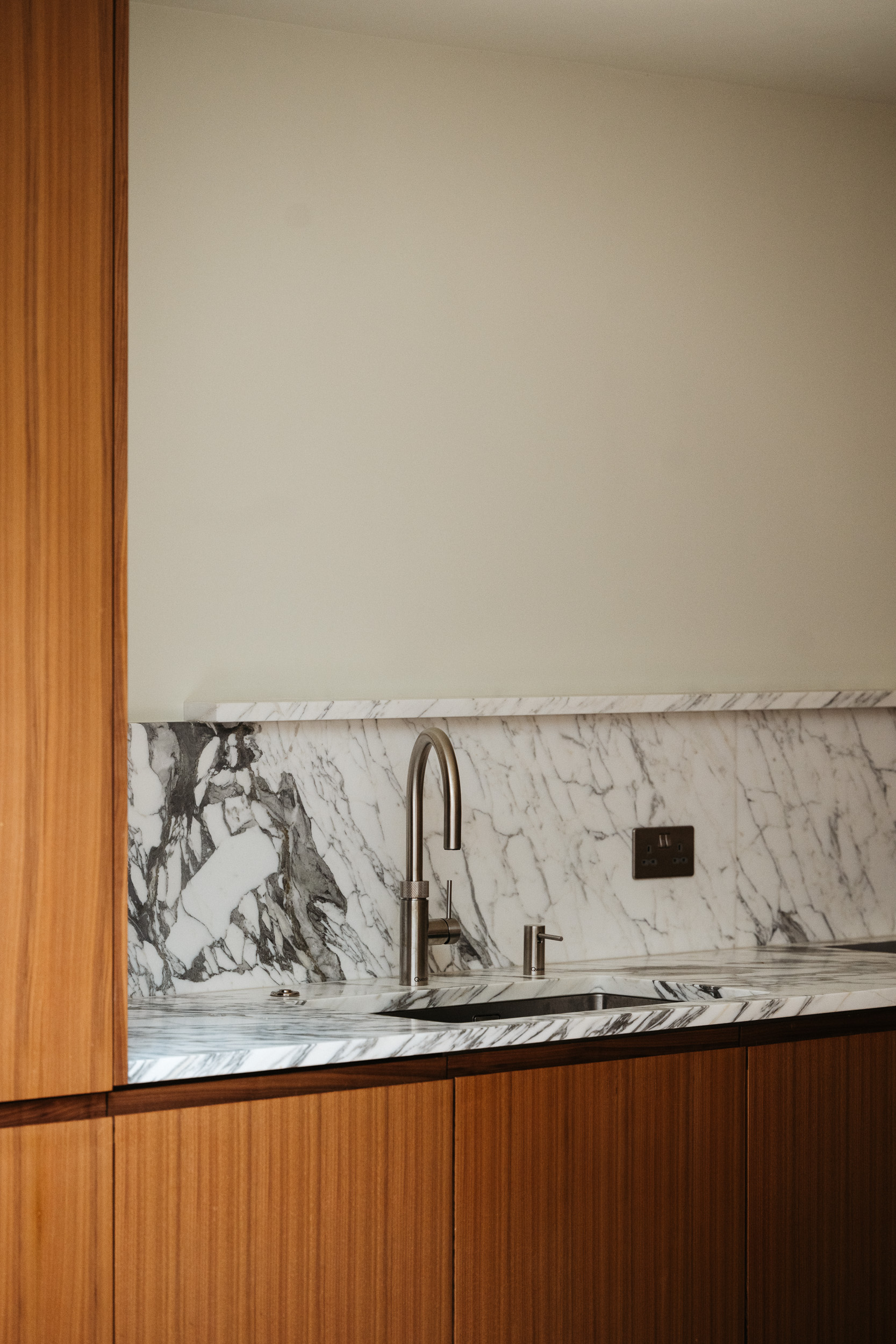 Contemporary walnut timber and arabescato marble Ma-kon kitchen.