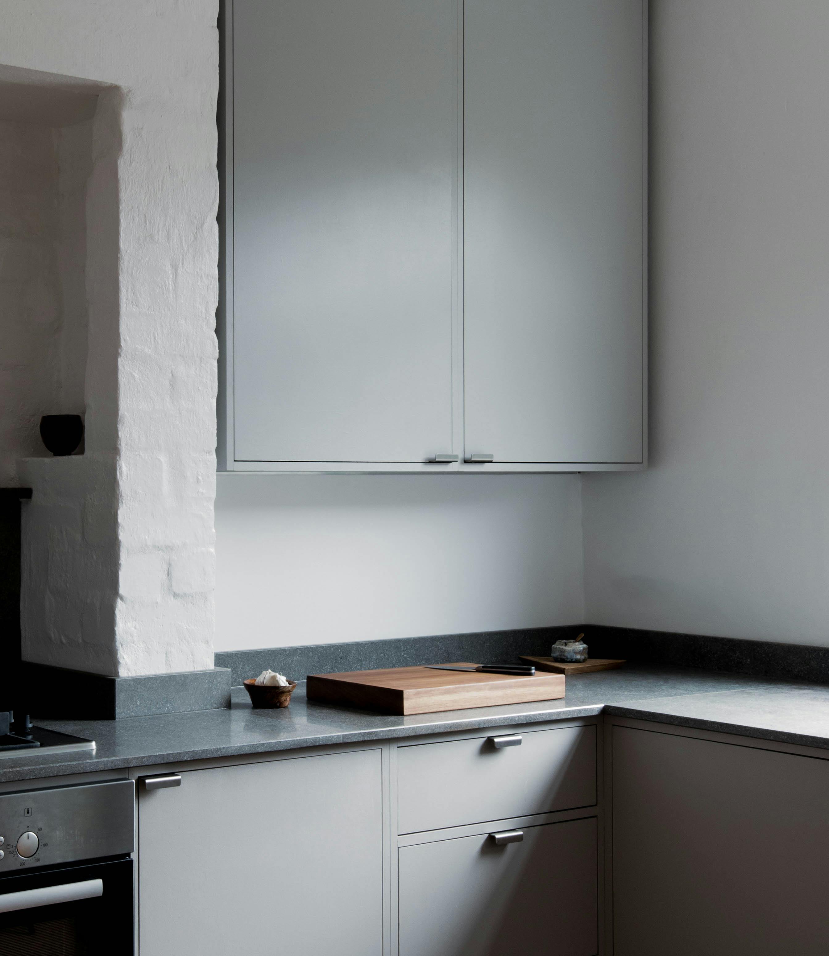 Minimal warm grey painted Ma-kon kitchen with limestone worktops.