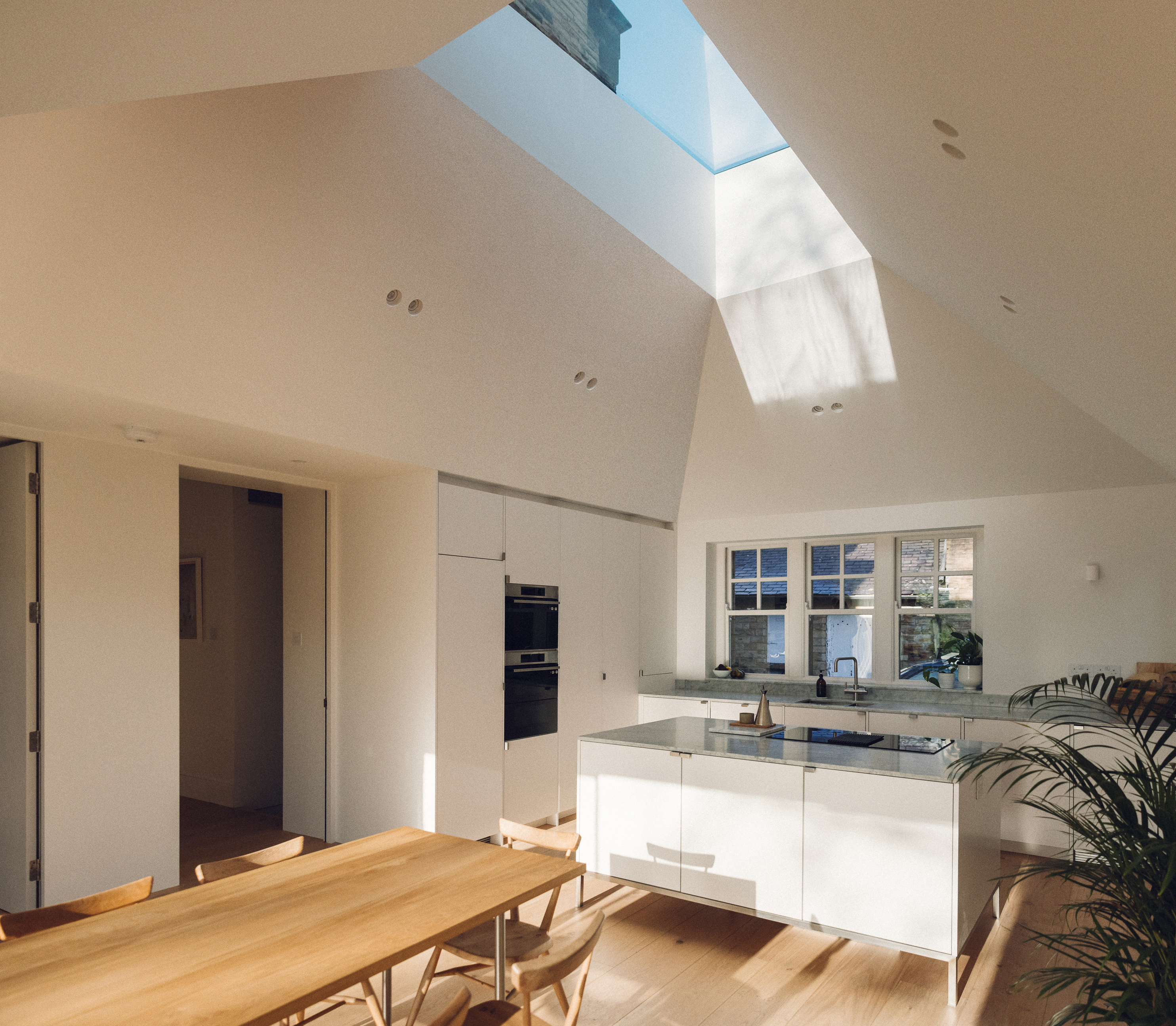 Minimal white painted Ma-kon kitchen with Carrara marble worktop.