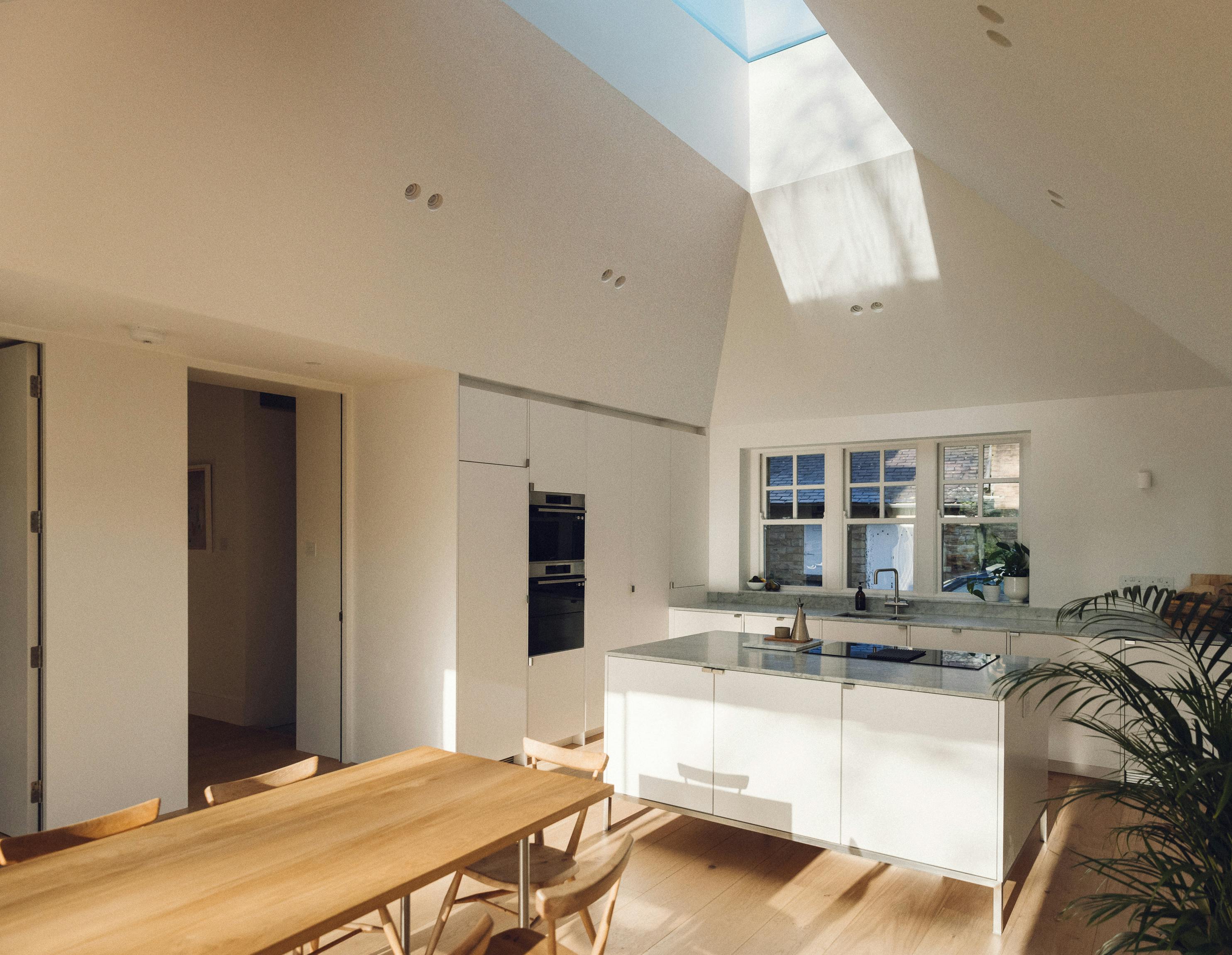 Minimal white painted Ma-kon kitchen with Carrara marble worktop.