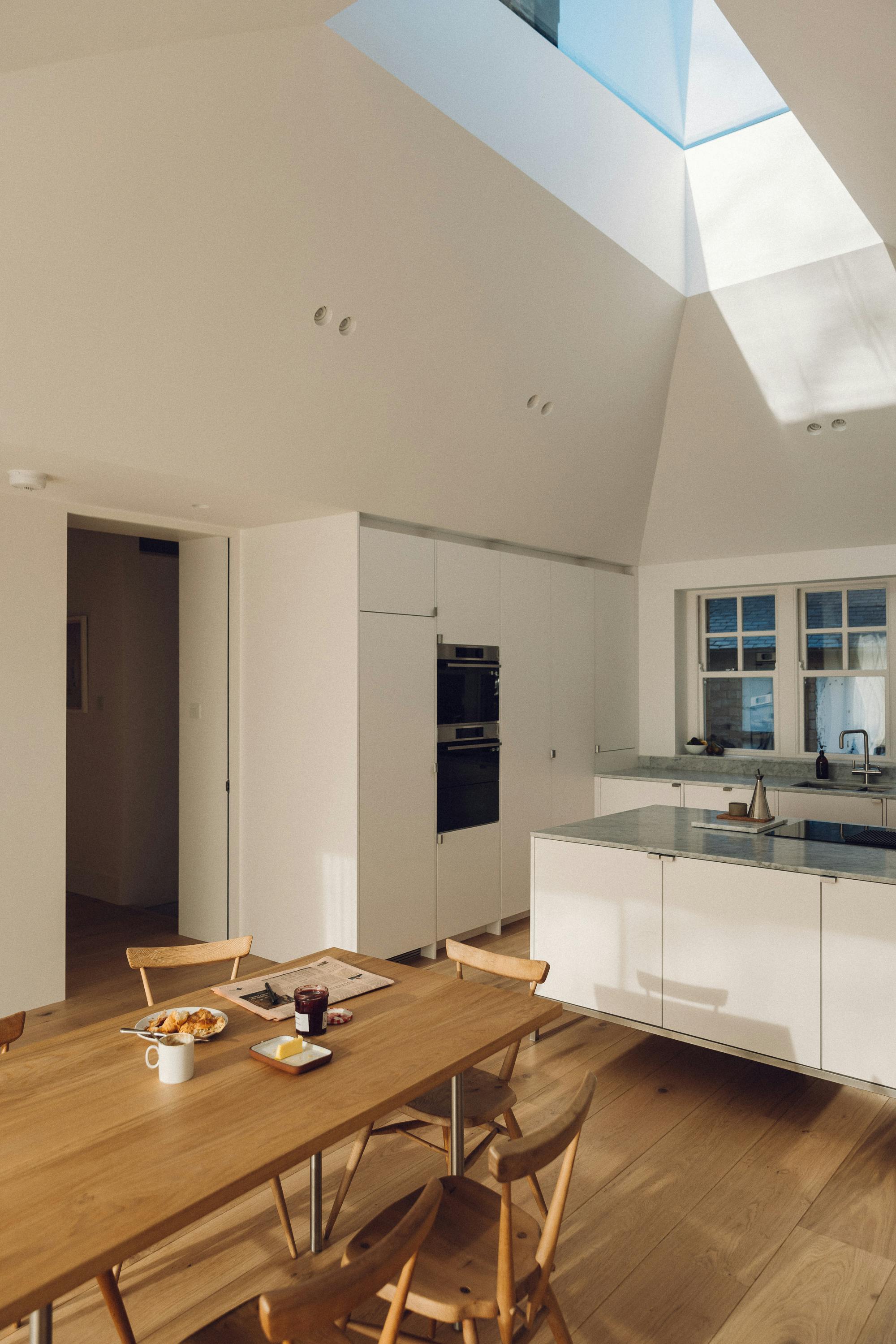 Minimal white painted Ma-kon kitchen with Carrara marble worktop.