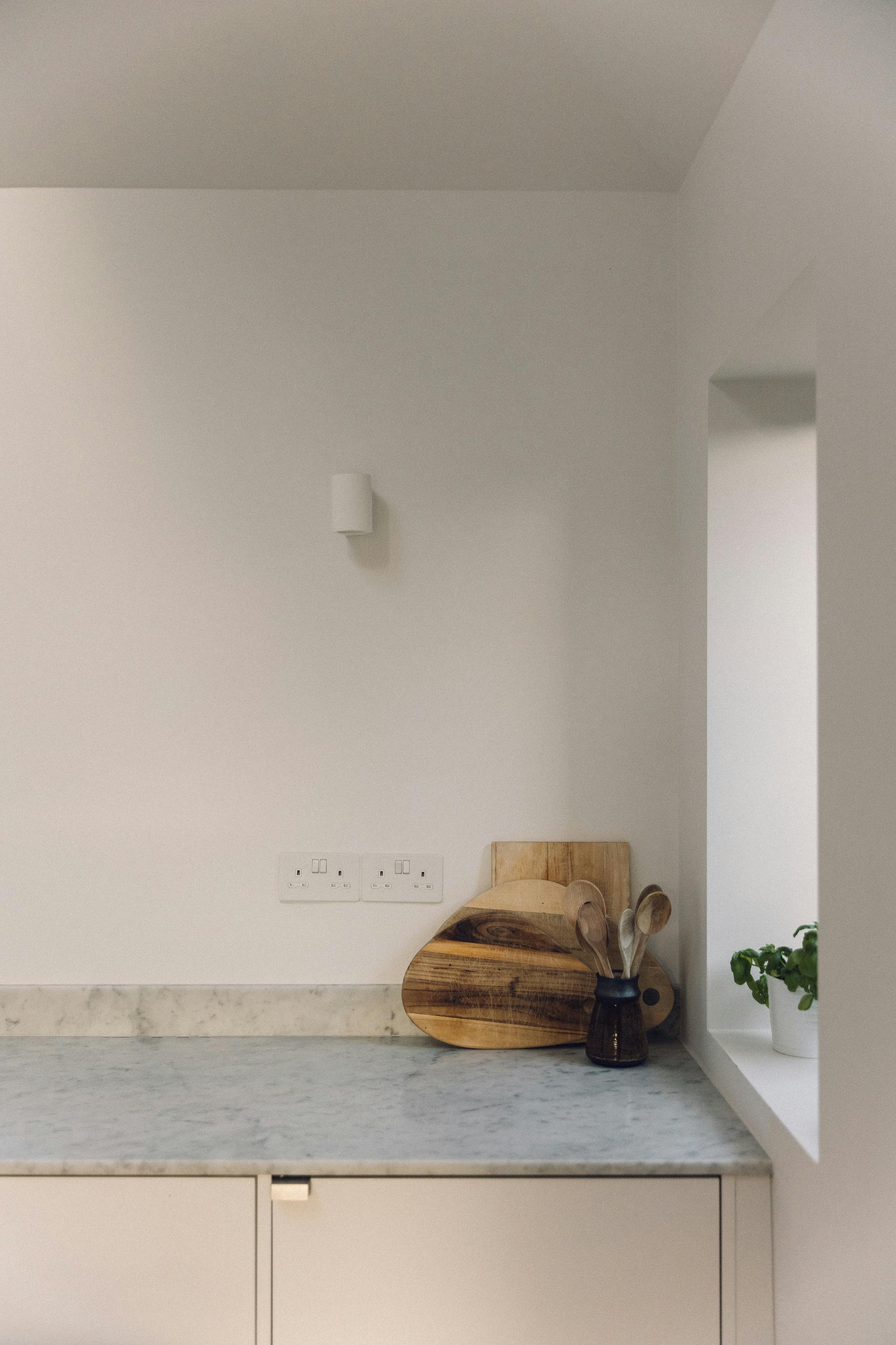Minimal white painted Ma-kon kitchen with Carrara marble worktop.