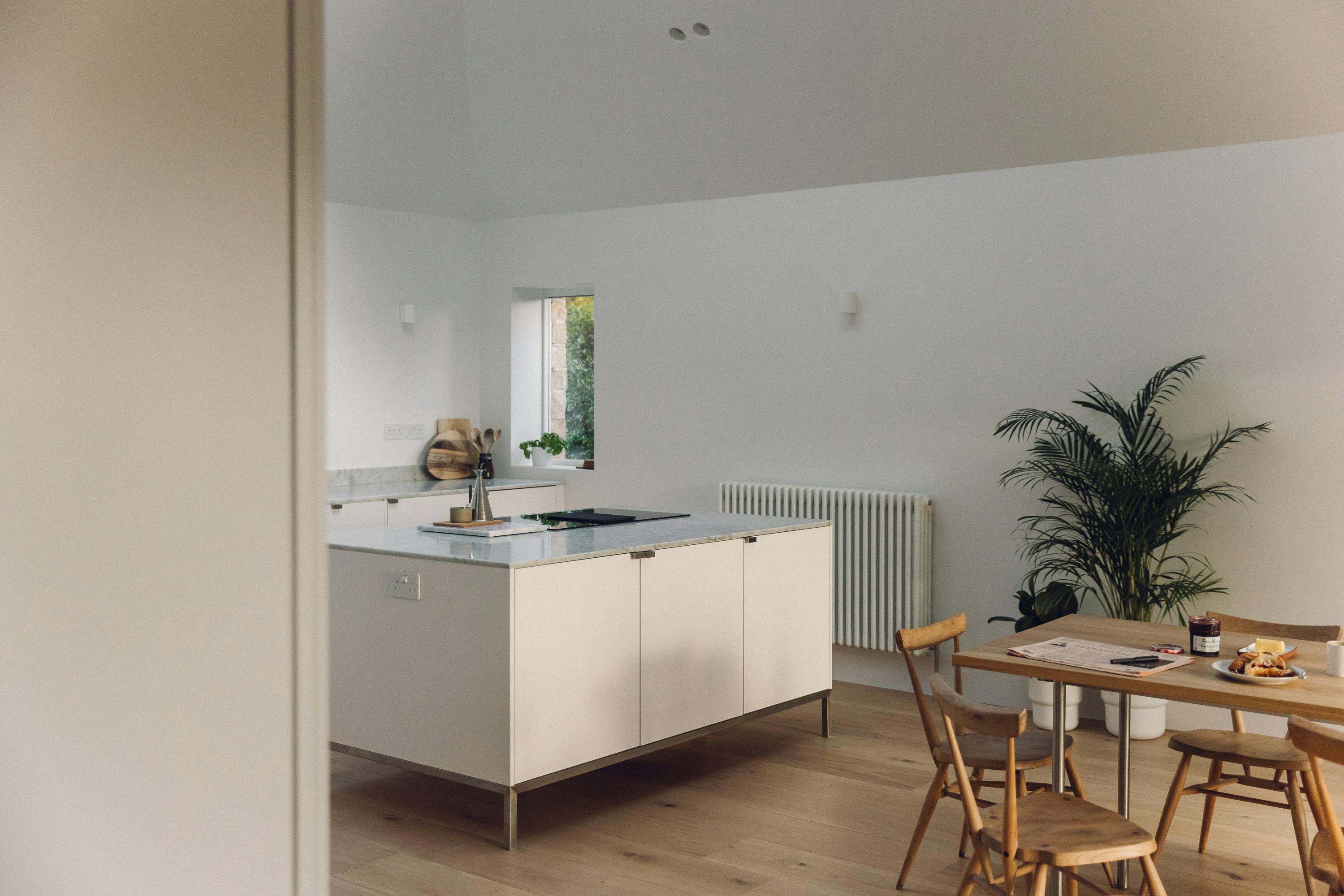 Minimal white painted Ma-kon kitchen with Carrara marble worktop.