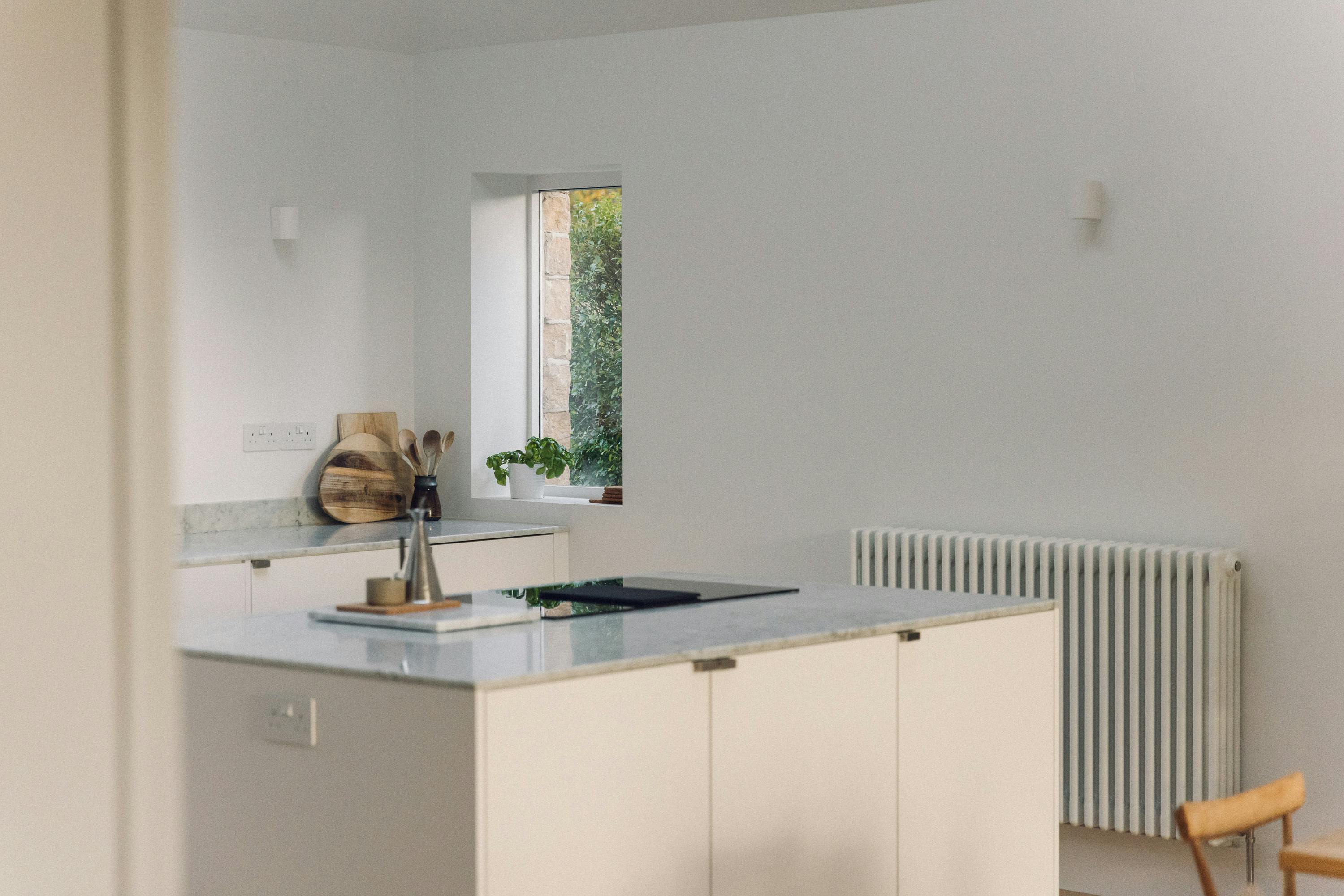 Minimal white painted Ma-kon kitchen with Carrara marble worktop.
