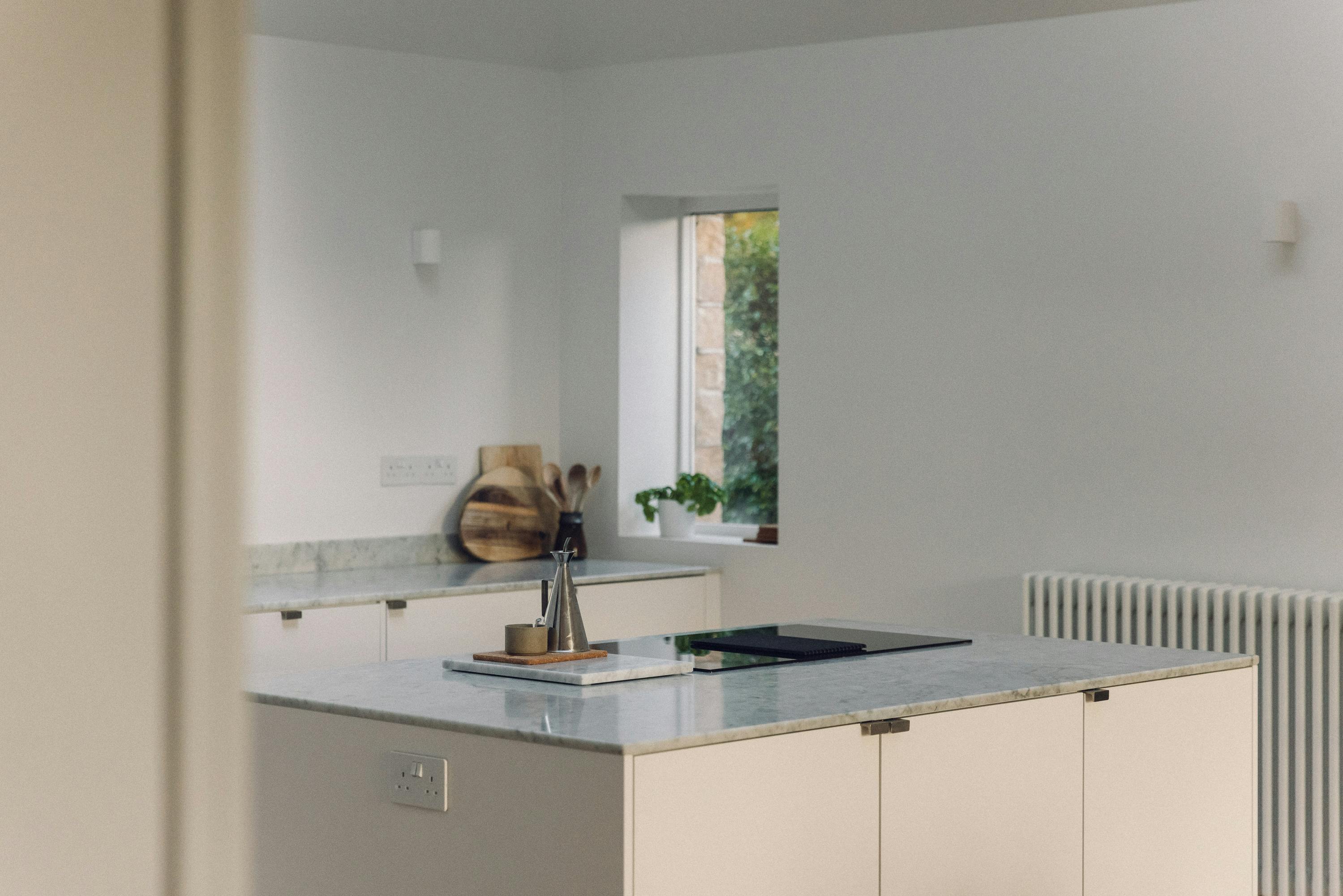 Minimal white painted Ma-kon kitchen with Carrara marble worktop.