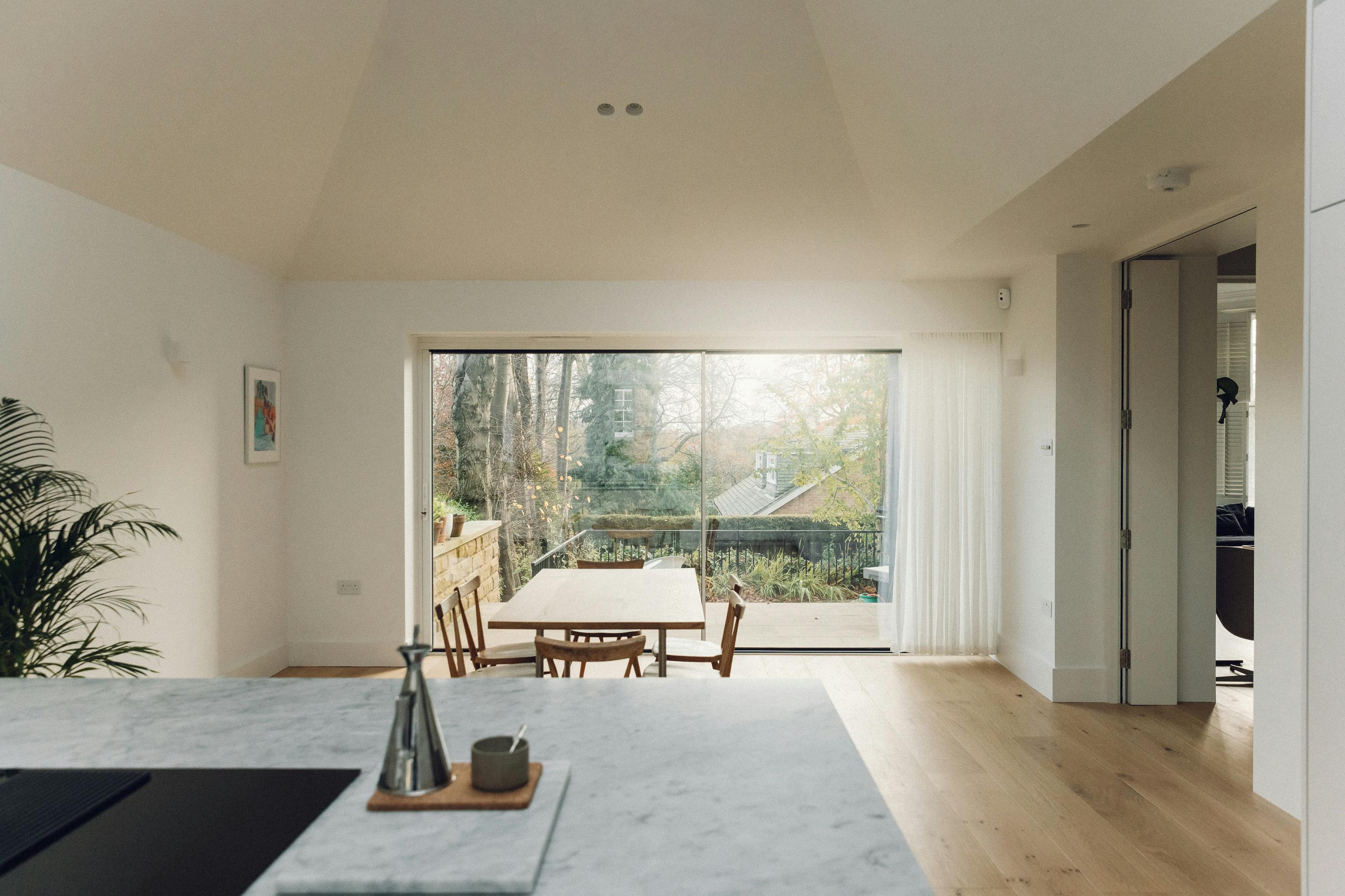 Minimal white painted Ma-kon kitchen with Carrara marble worktop.