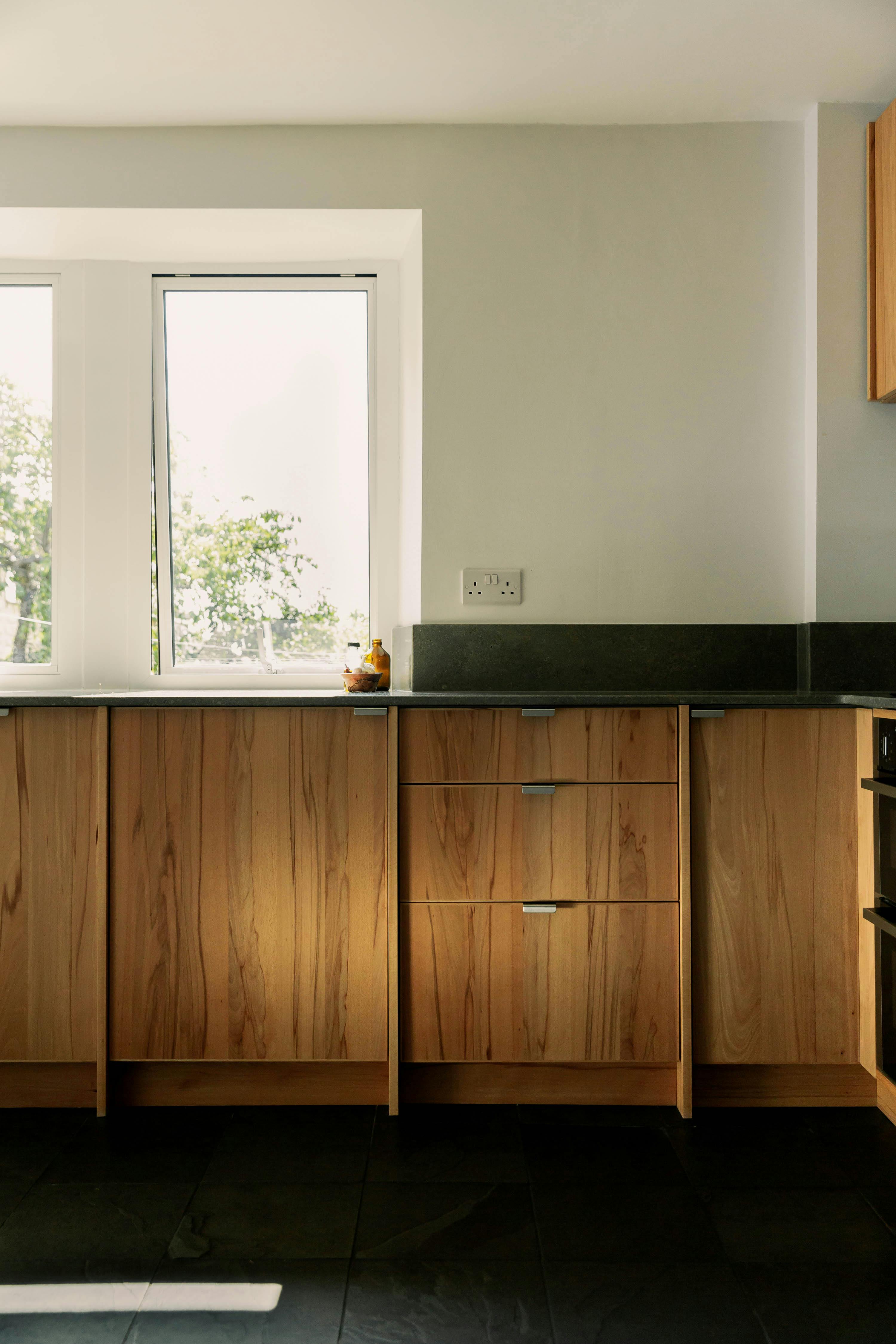 Contemporary wooden Ma-kon kitchen with limestone worktop.
