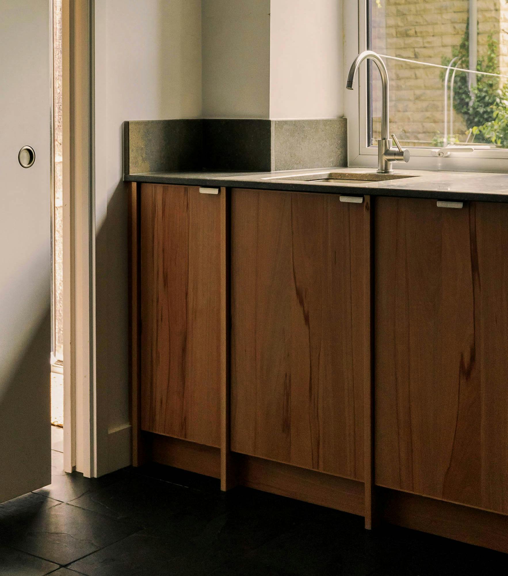 Contemporary wooden Ma-kon kitchen with limestone worktop.