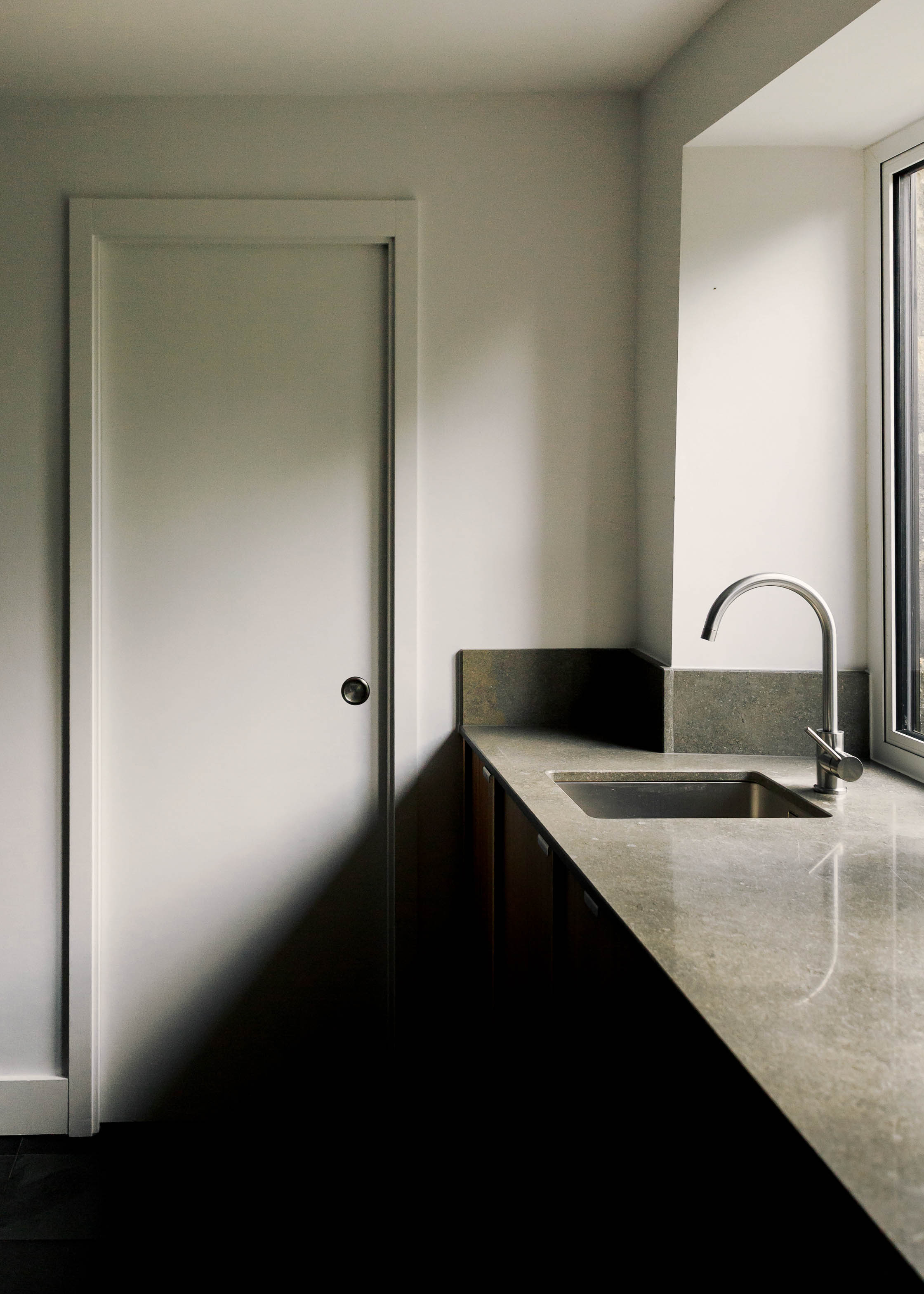 Contemporary wooden Ma-kon kitchen with limestone worktop.