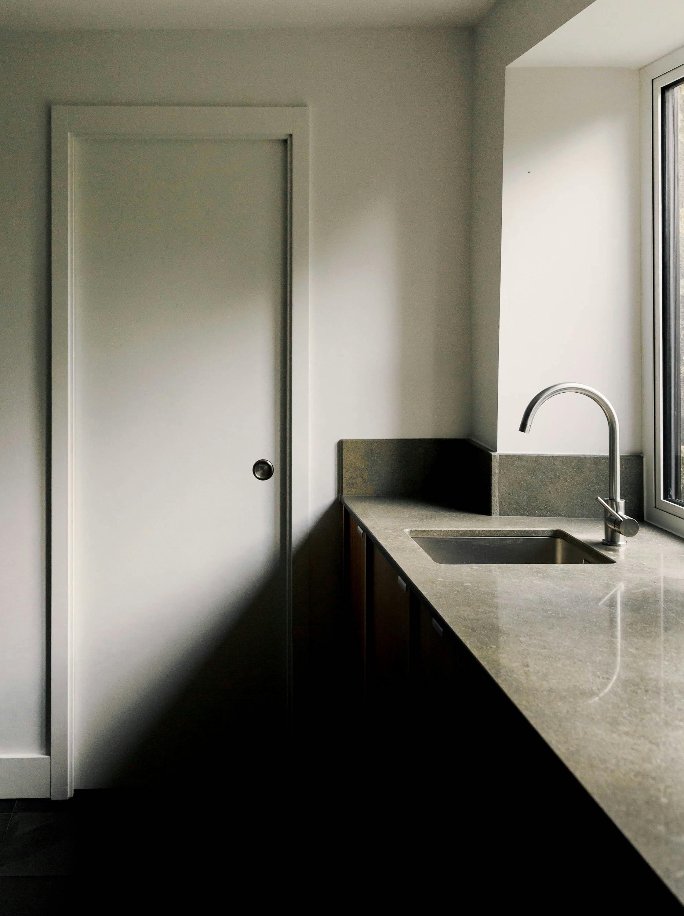 Contemporary wooden Ma-kon kitchen with limestone worktop.