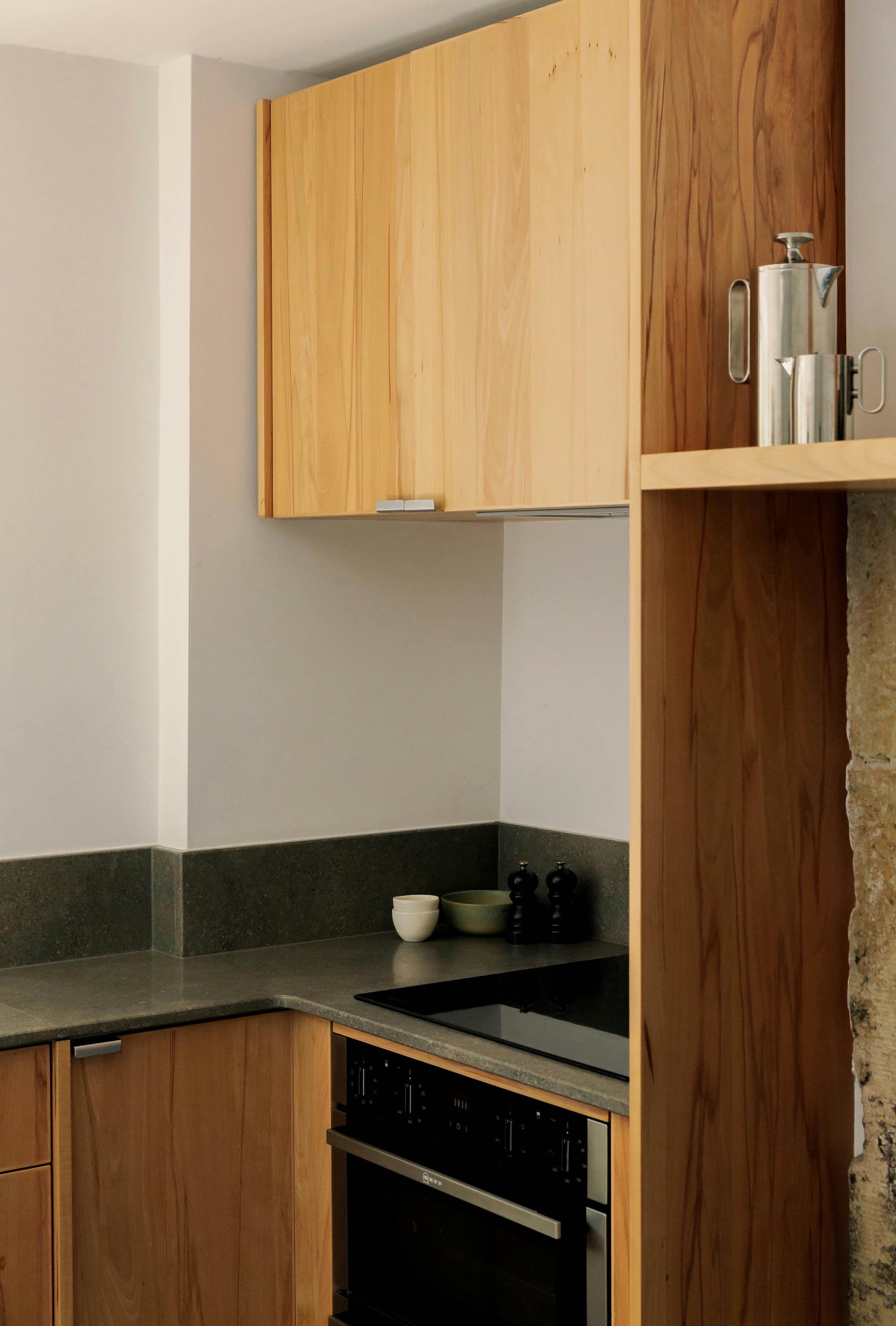 Contemporary wooden Ma-kon kitchen with limestone worktop.