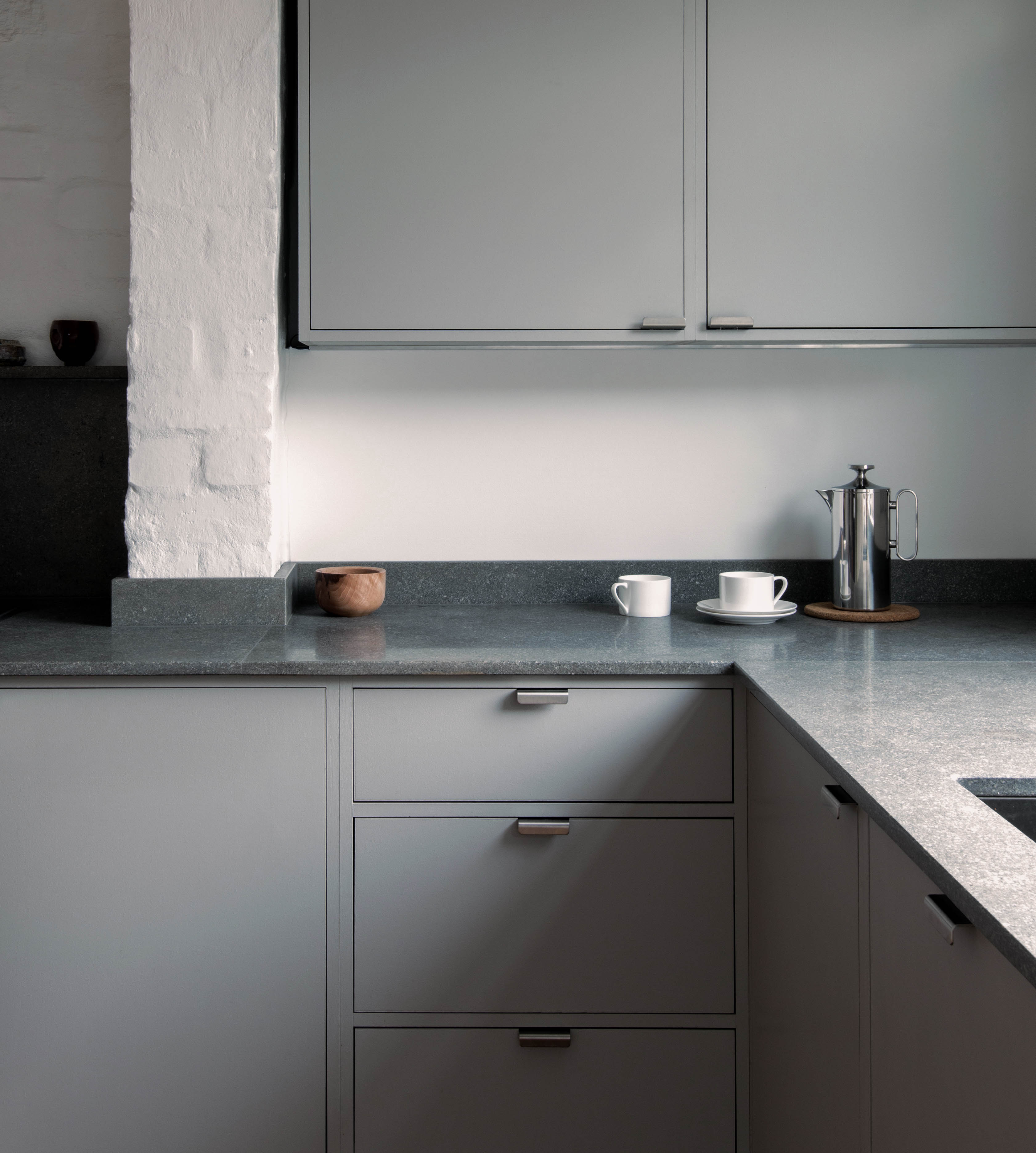 Minimal warm grey painted Ma-kon kitchen with limestone worktops.