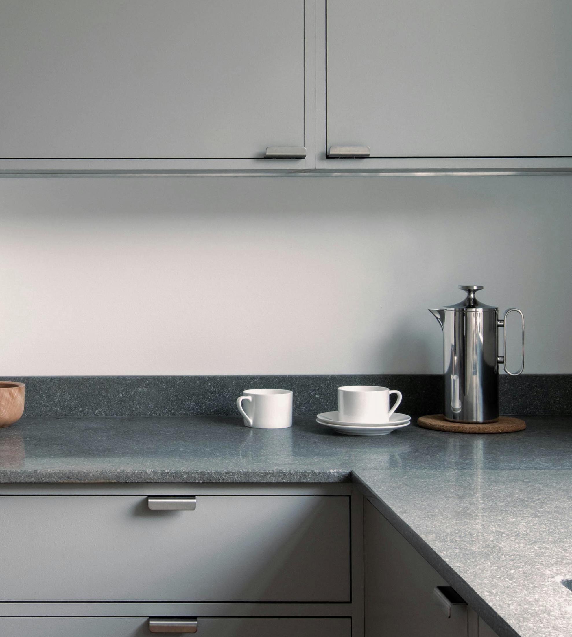 Minimal warm grey painted Ma-kon kitchen with limestone worktops.