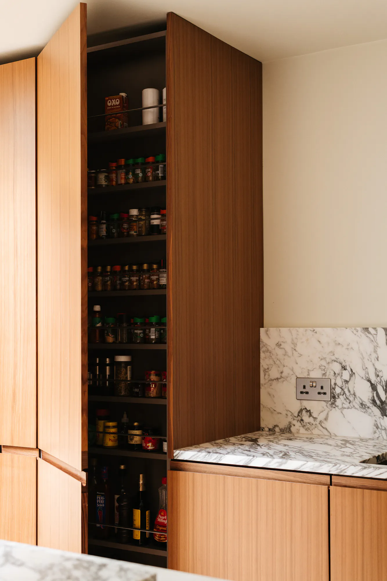 Contemporary walnut timber and arabescato marble Ma-kon kitchen.