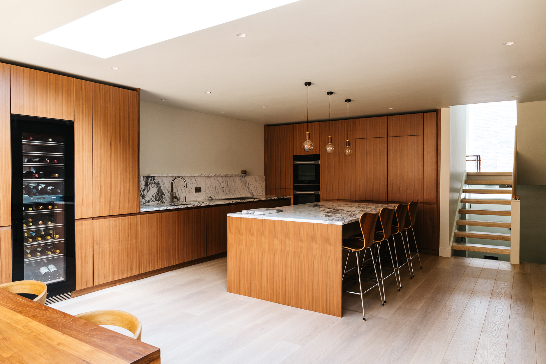 Contemporary walnut timber and arabescato marble Ma-kon kitchen.