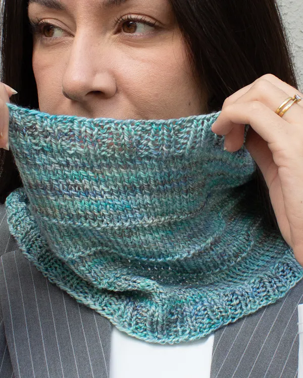 Woman wearing a hand-knit cowl in Torzal yarn, in Celestina color