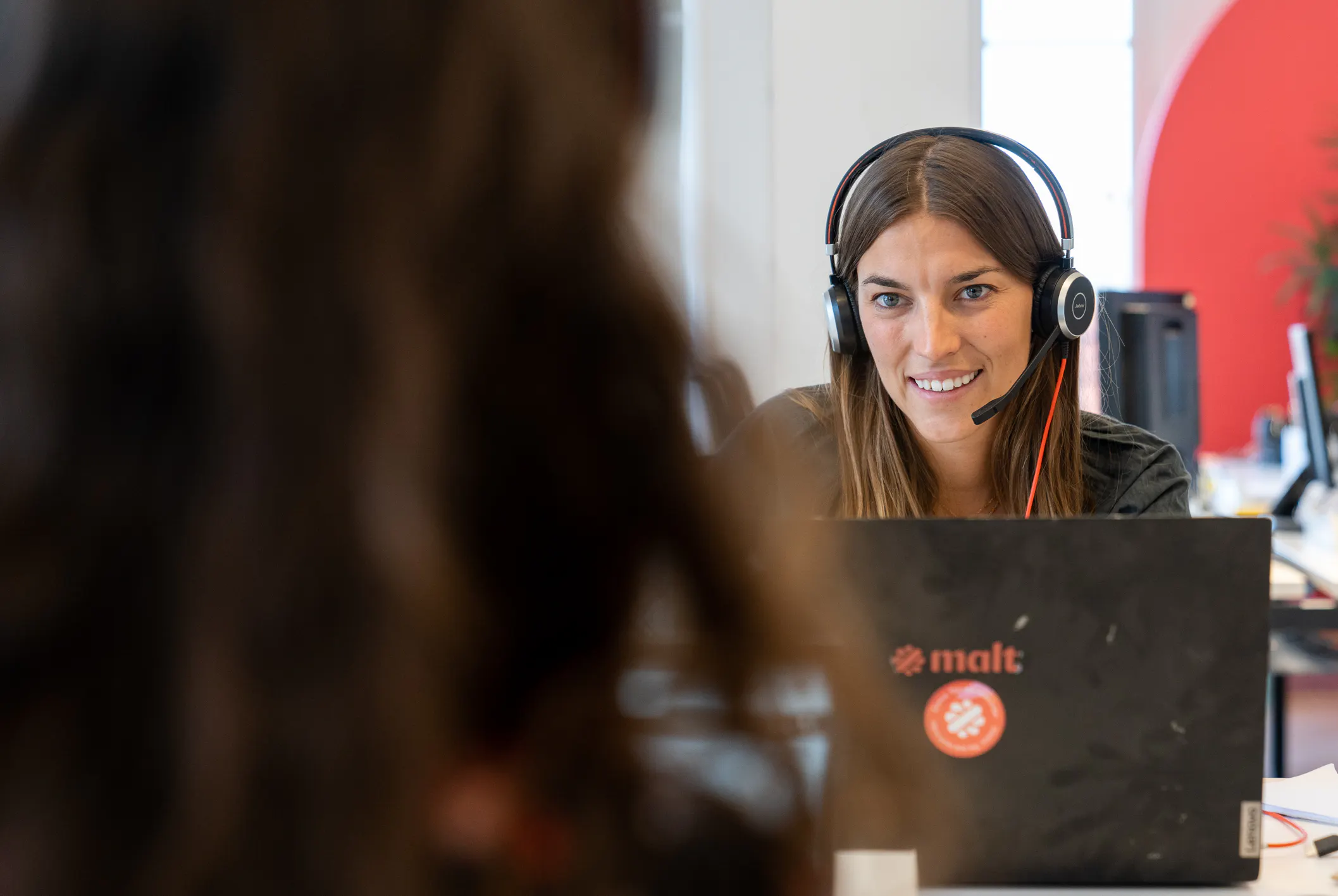 portrait of a woman with a headset working at Malt