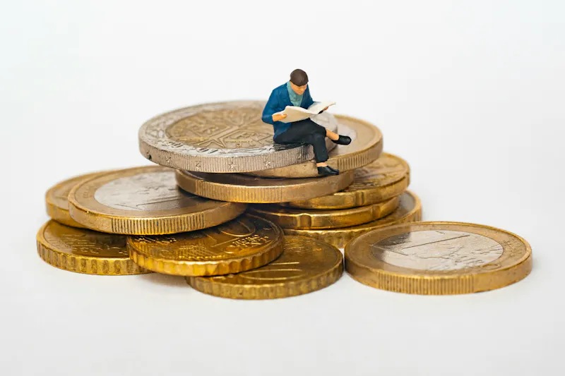 Une personne assise sur une pile de pièces de monnaie