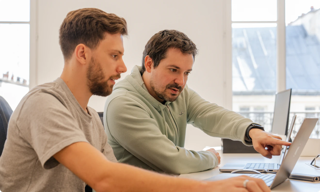 picture of two men working together with one pointing at a screen