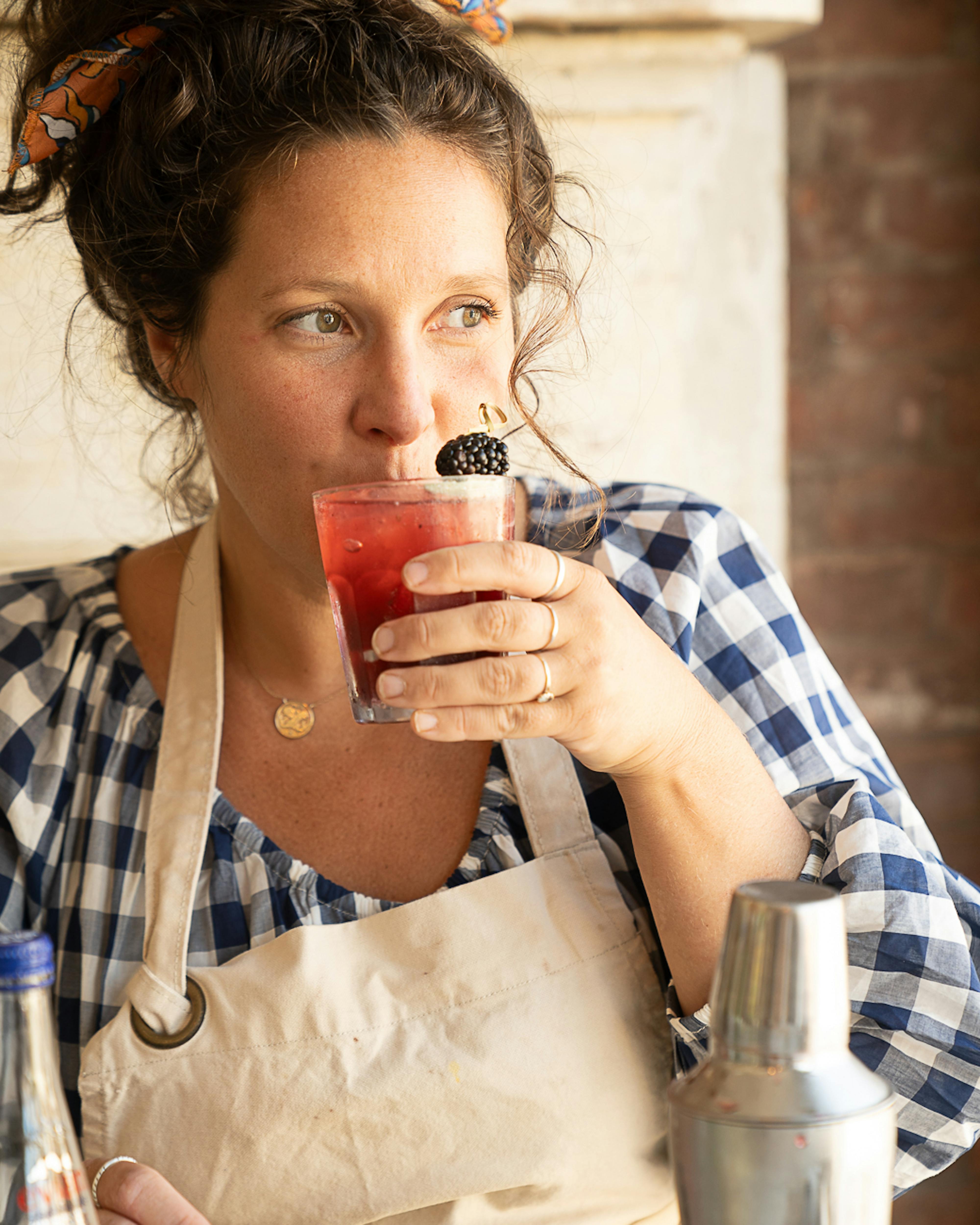 woman sipping blackberry sage spritz