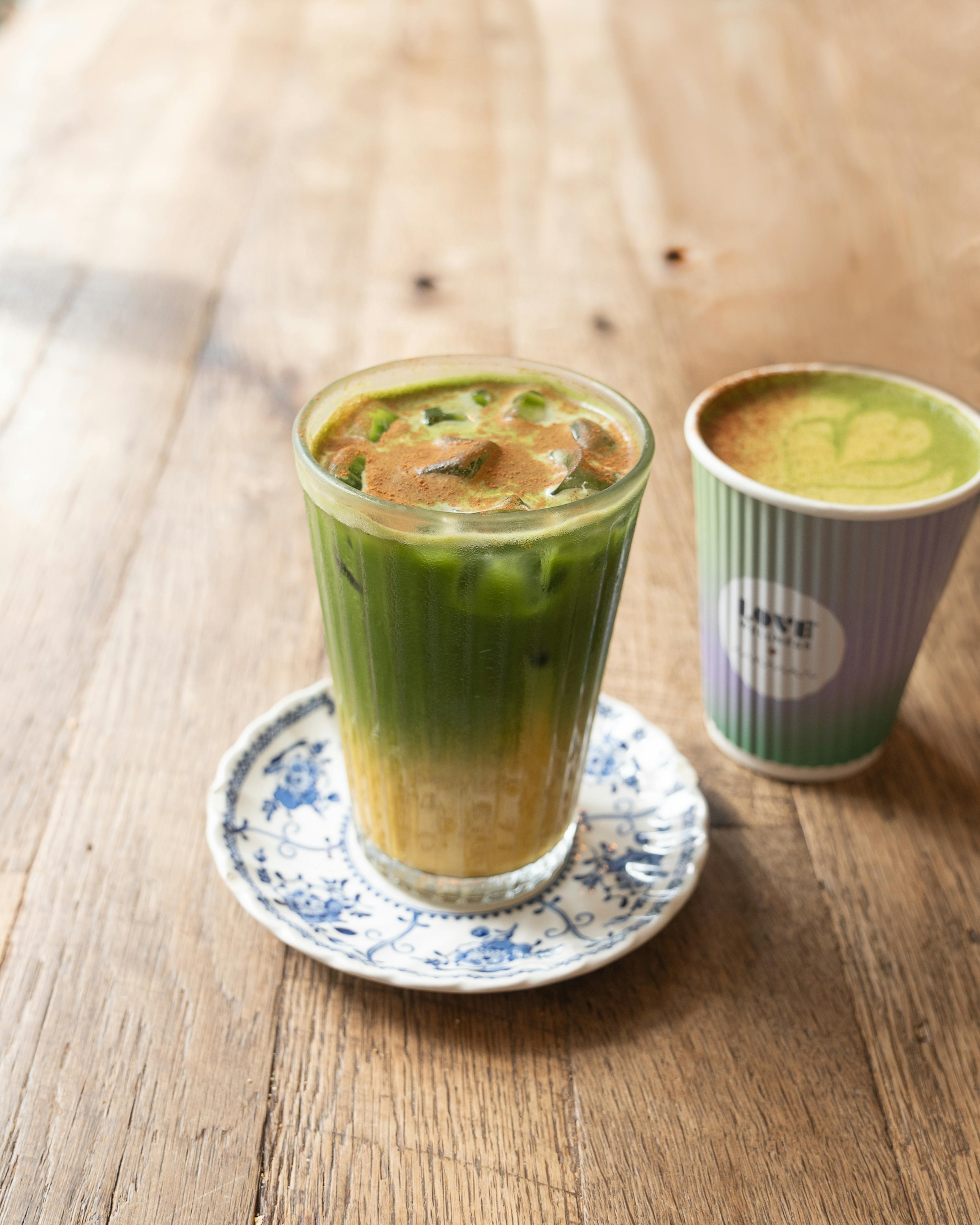 iced matcha latte on table with hot drink