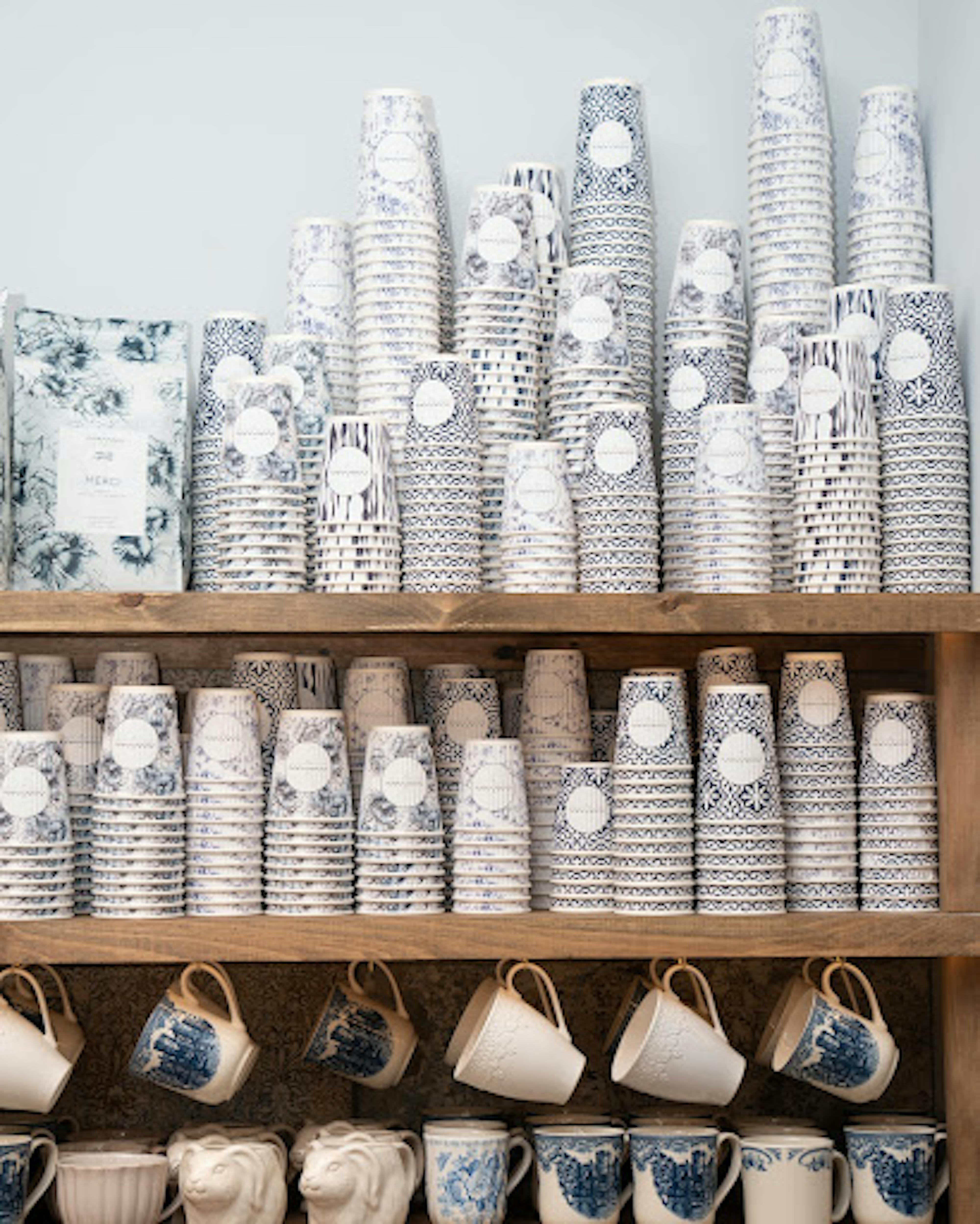 maman's signature to-go coffee cups displayed on open shelfing