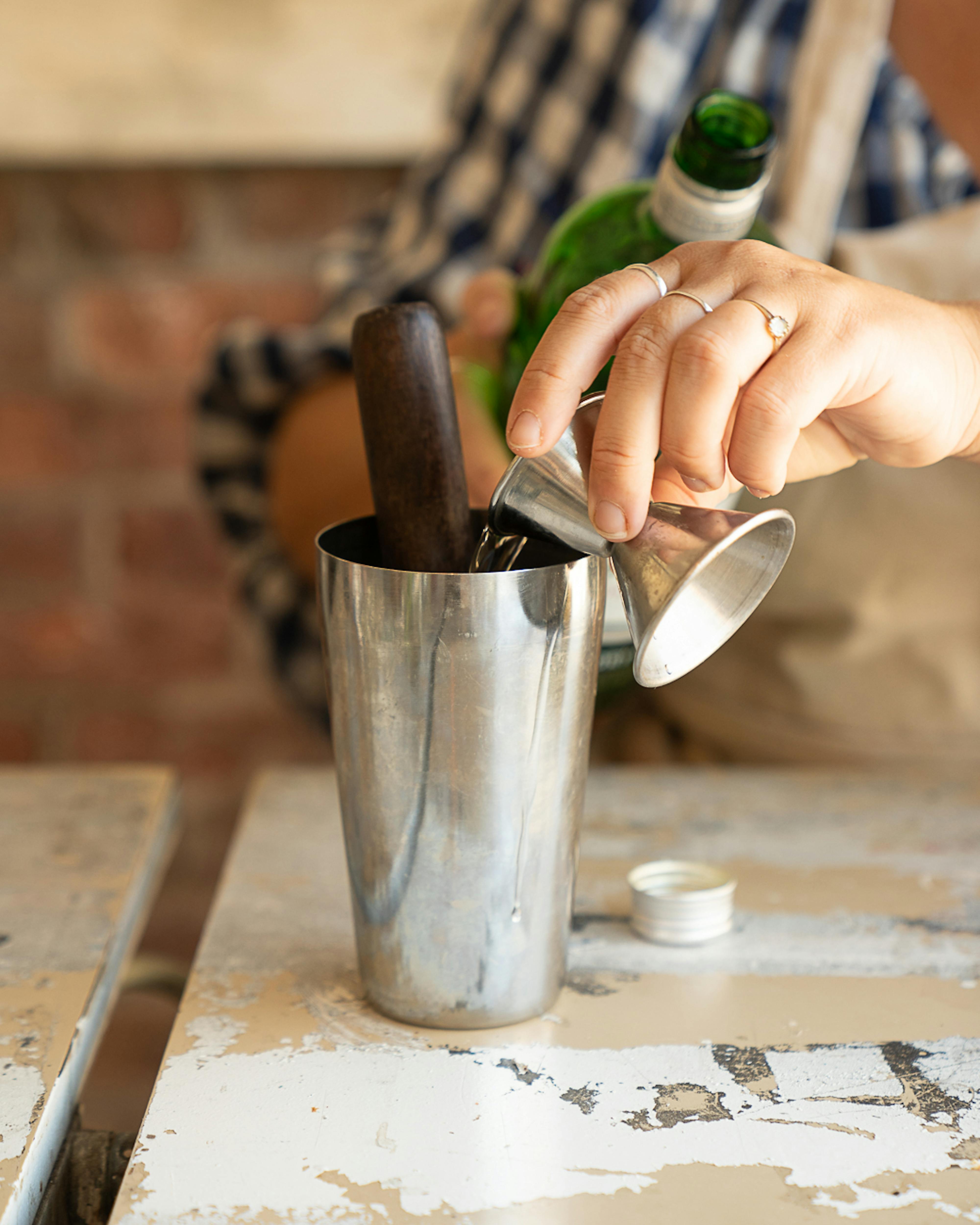 adding gin to cocktail shaker