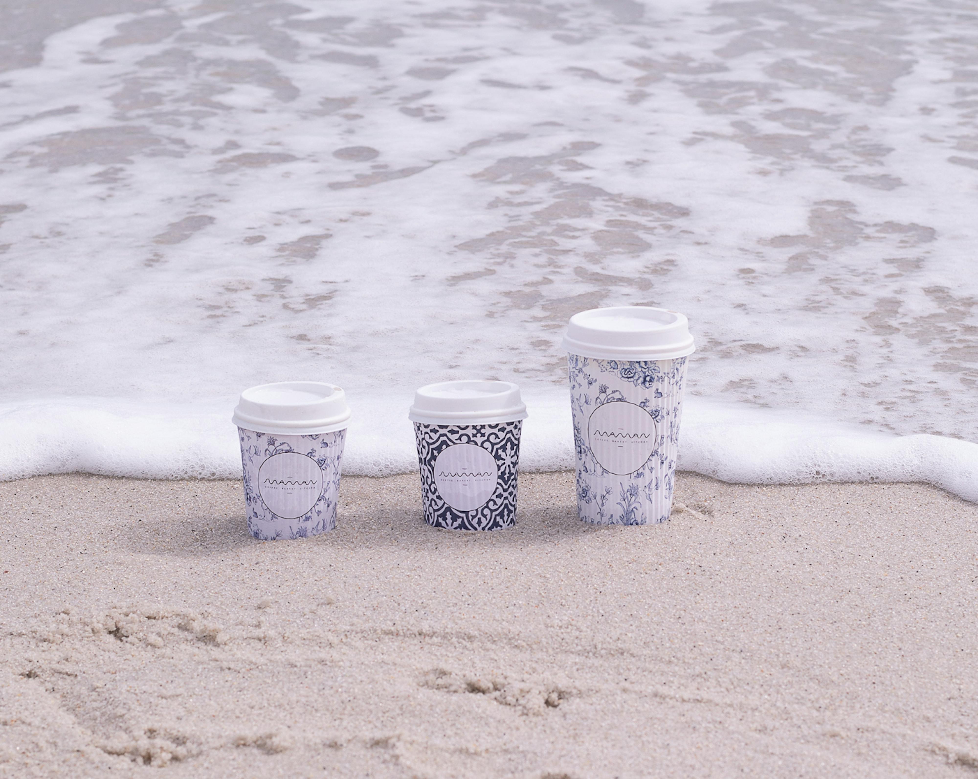 maman cups in the sand on the beach with wave