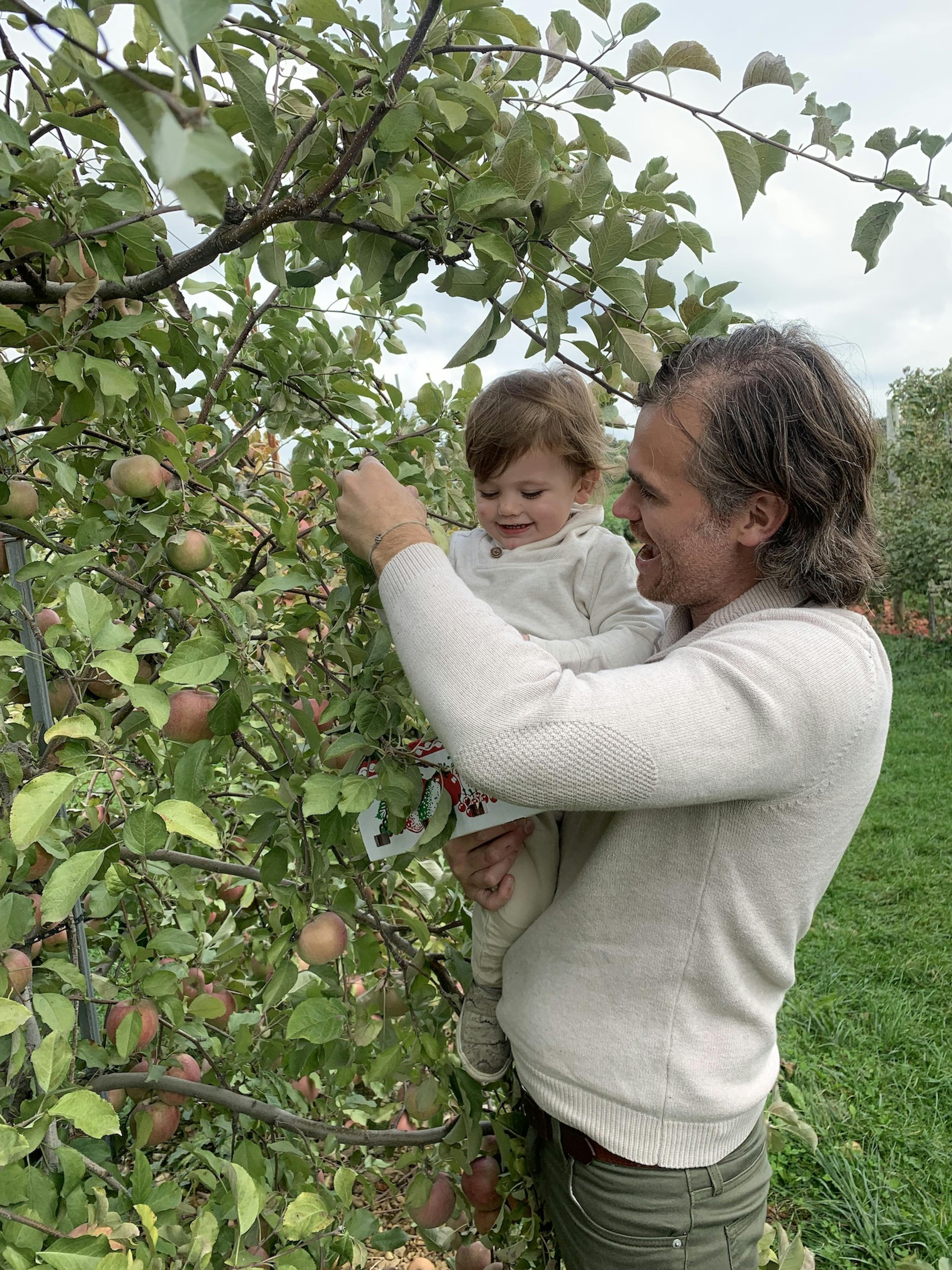 Founder Ben picking apples with his son, Yves.