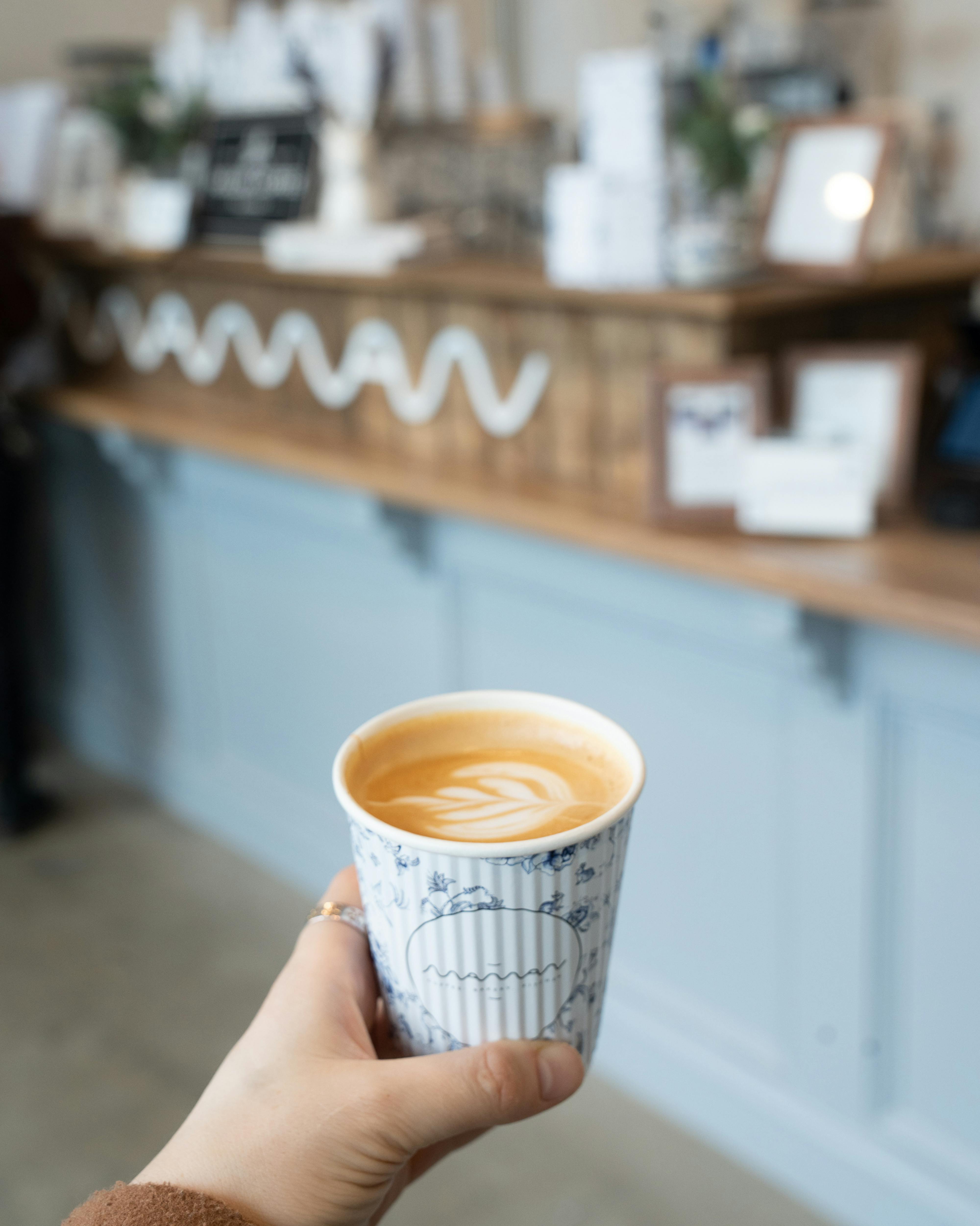 holding coffee in front of a counter