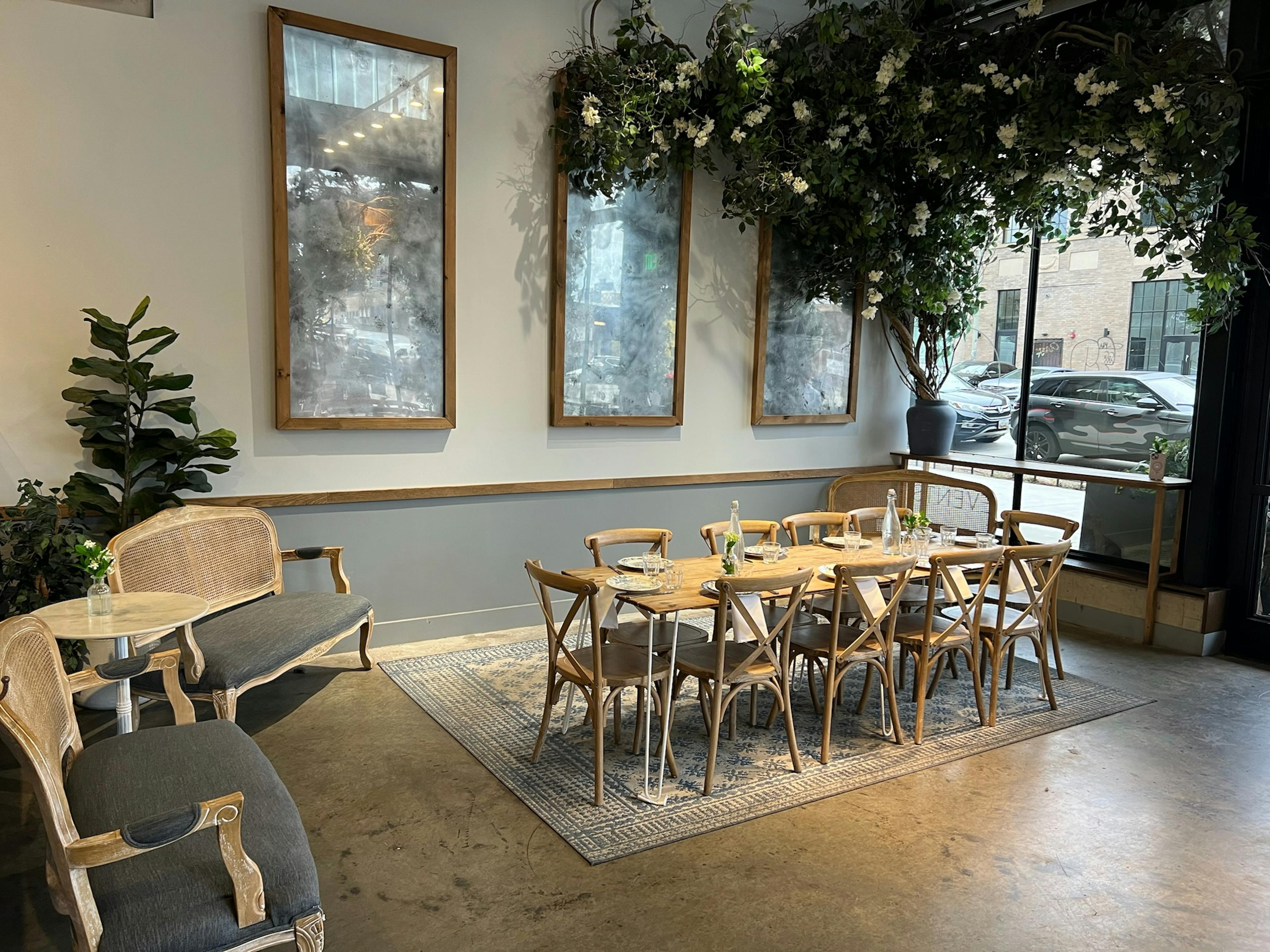 lounge area of maman union market café transformed into event space, complete with a rustic wooden farm table and elegant table setting.