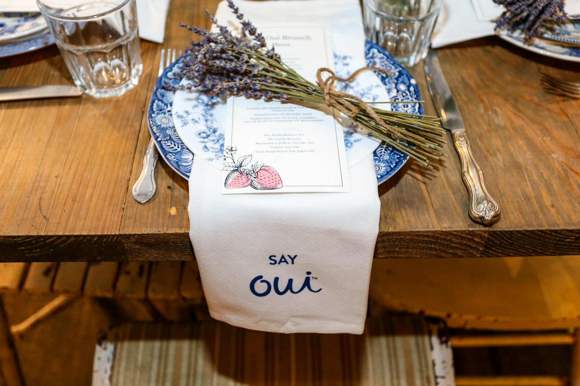 table setting with blue plate, lavender sprig and white linen napkin