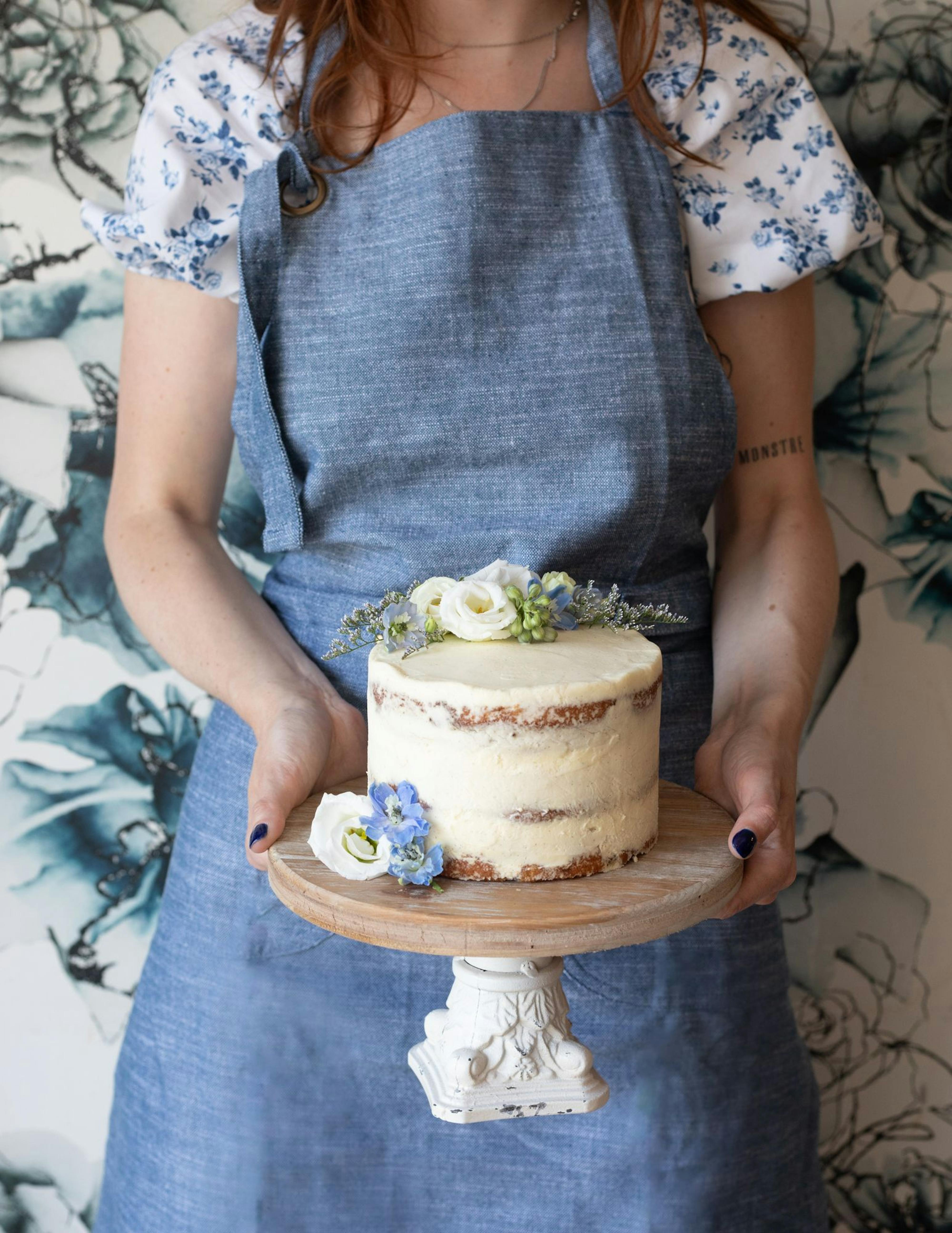 woman in apron holding cake