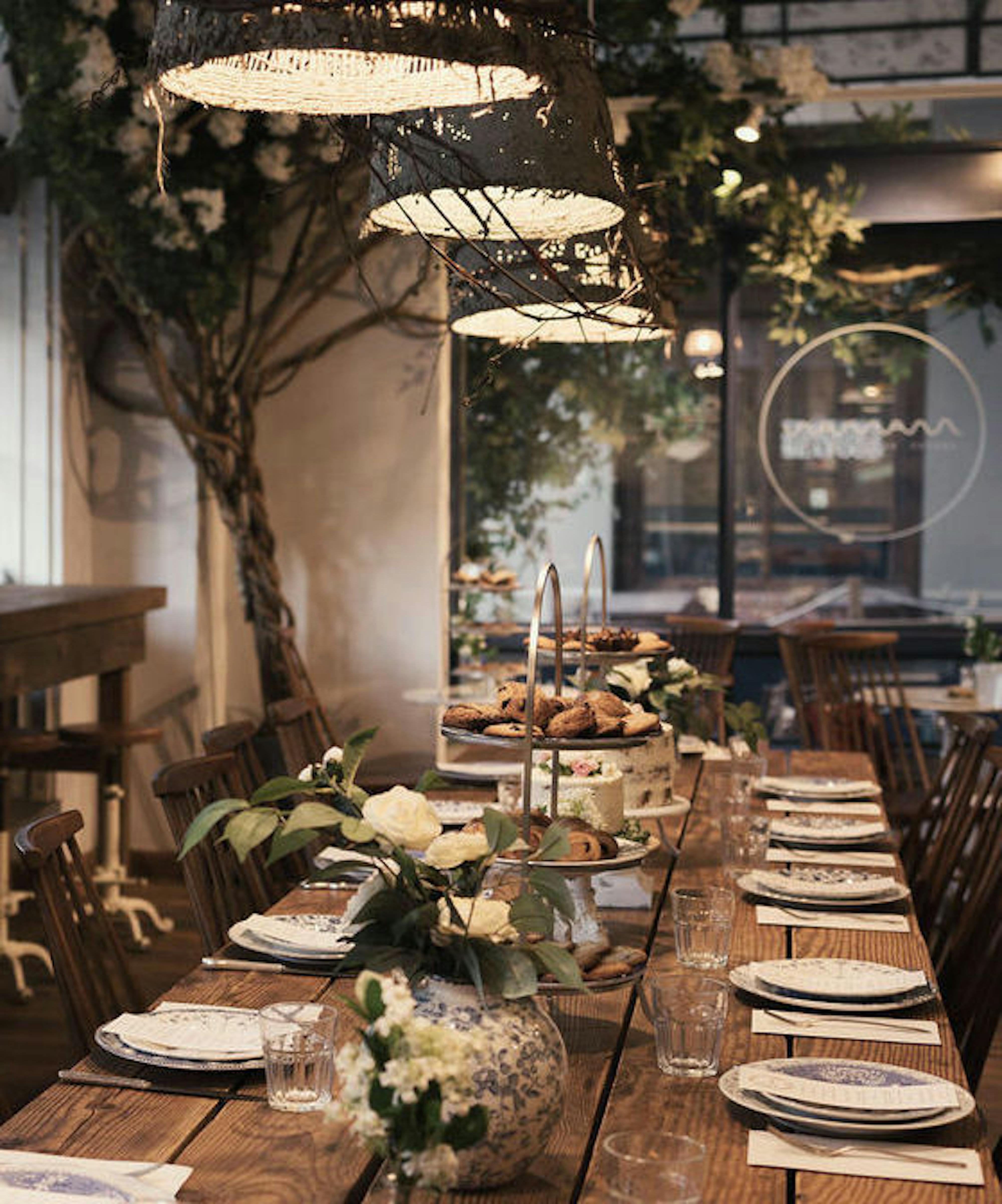 communal table with place settings and dessert on tiered stands