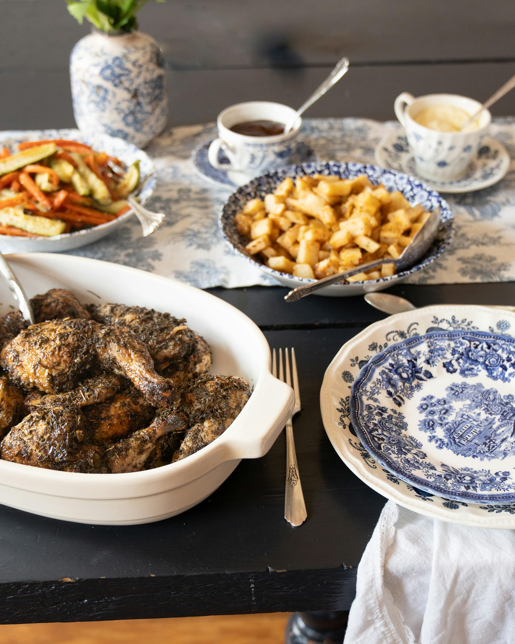 roasted chicken and potatoes on table with place setting