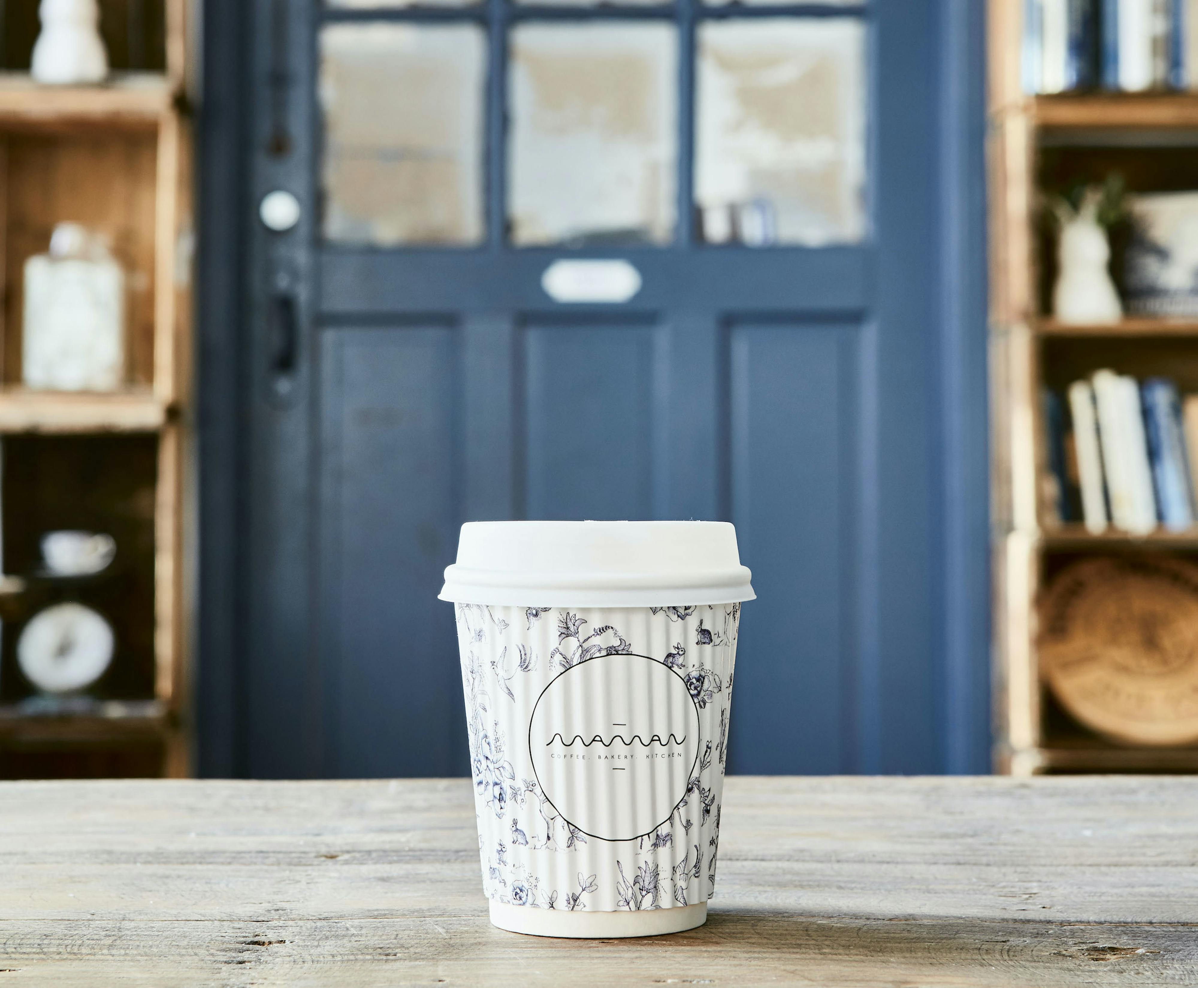 cup in front of blue door at hudson café