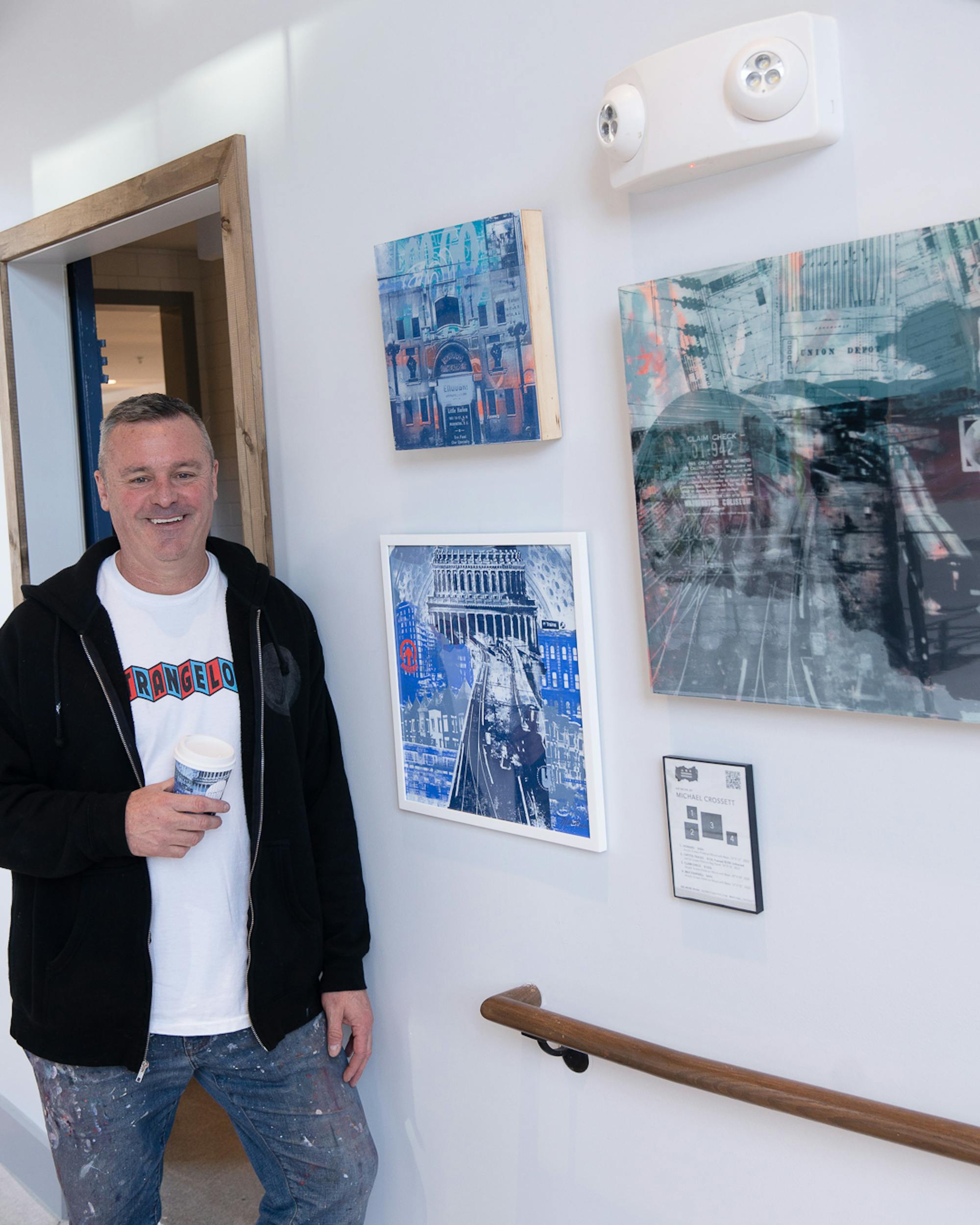 artist michael crossett with his artwork in our union market dc café