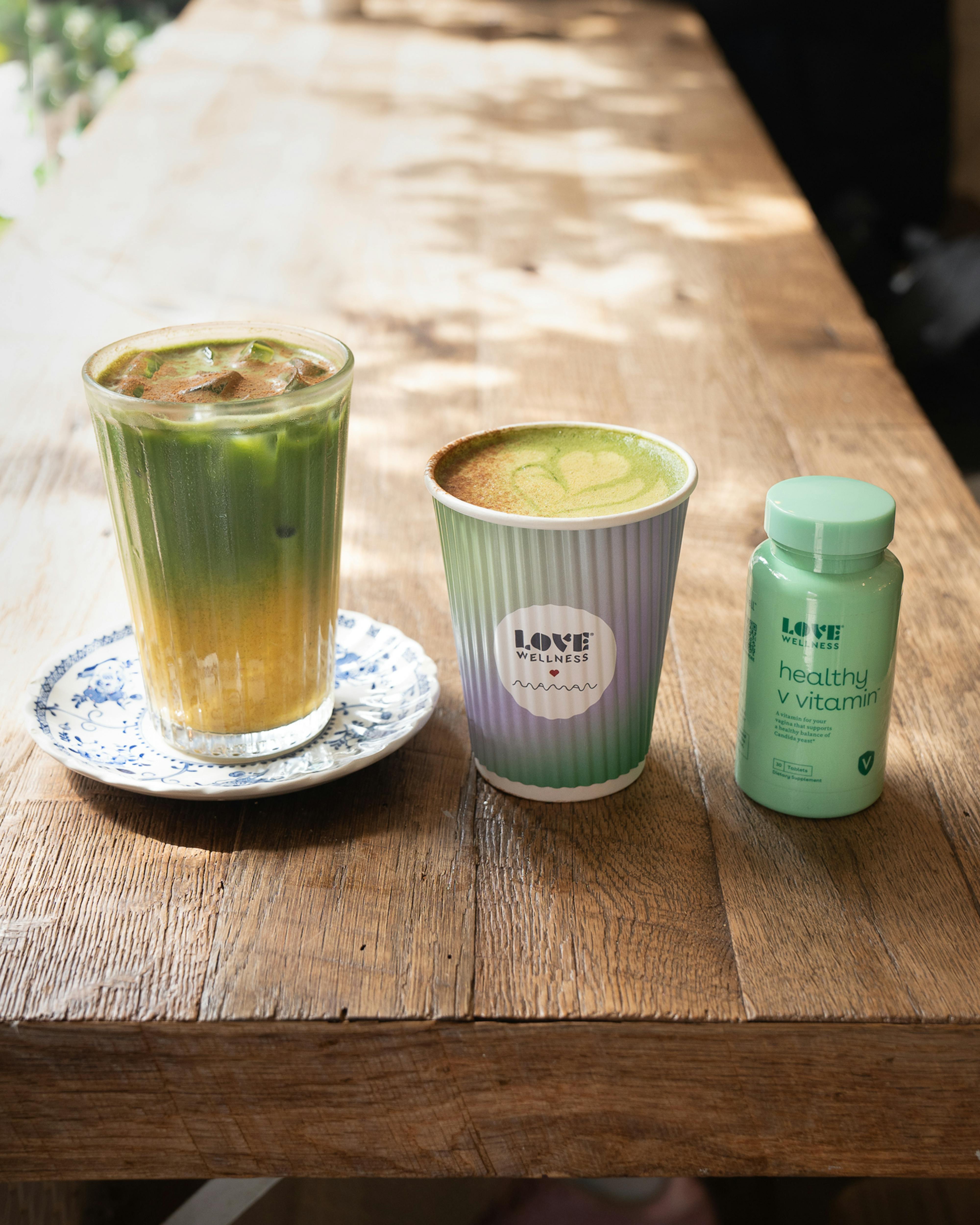 iced matcha latte on table with love wellness branded cups