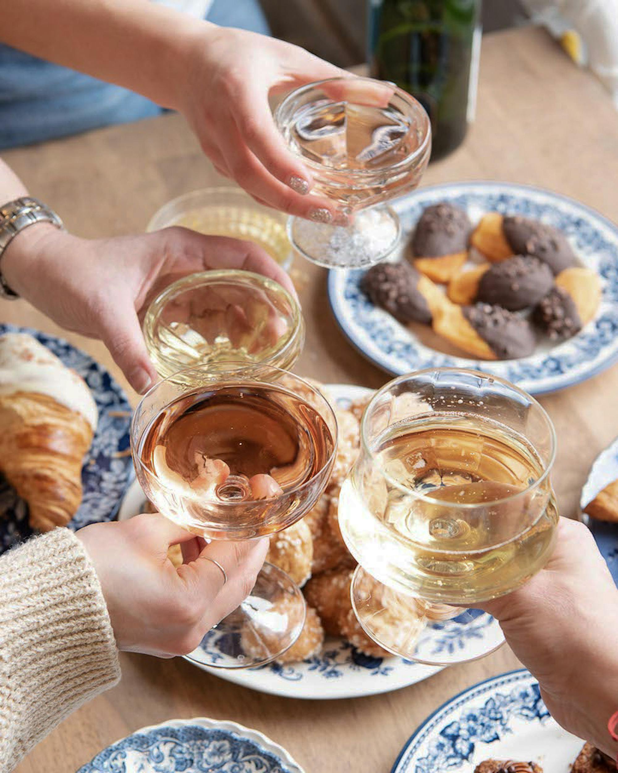 people clinking wine glasses