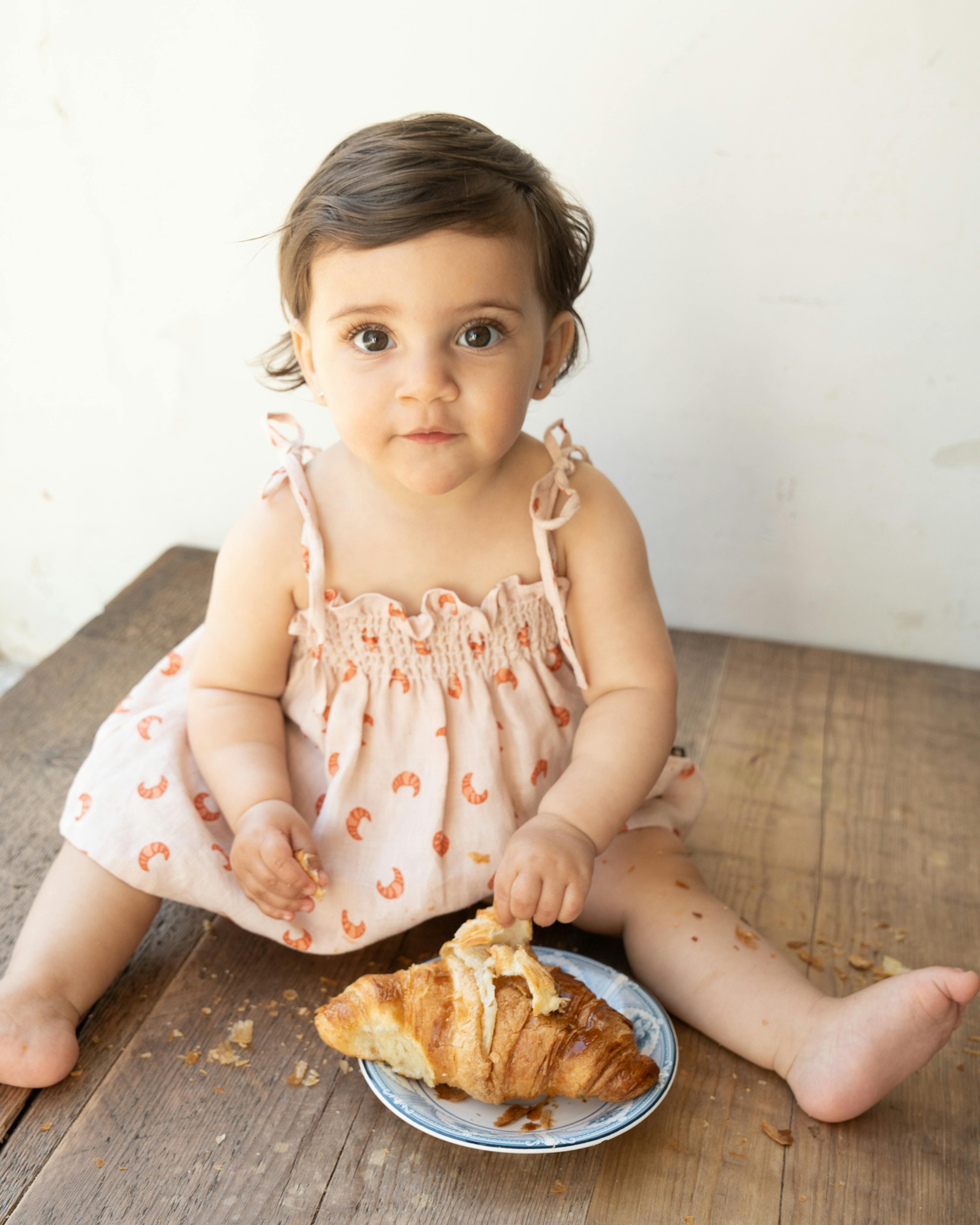 baby on table with croissant