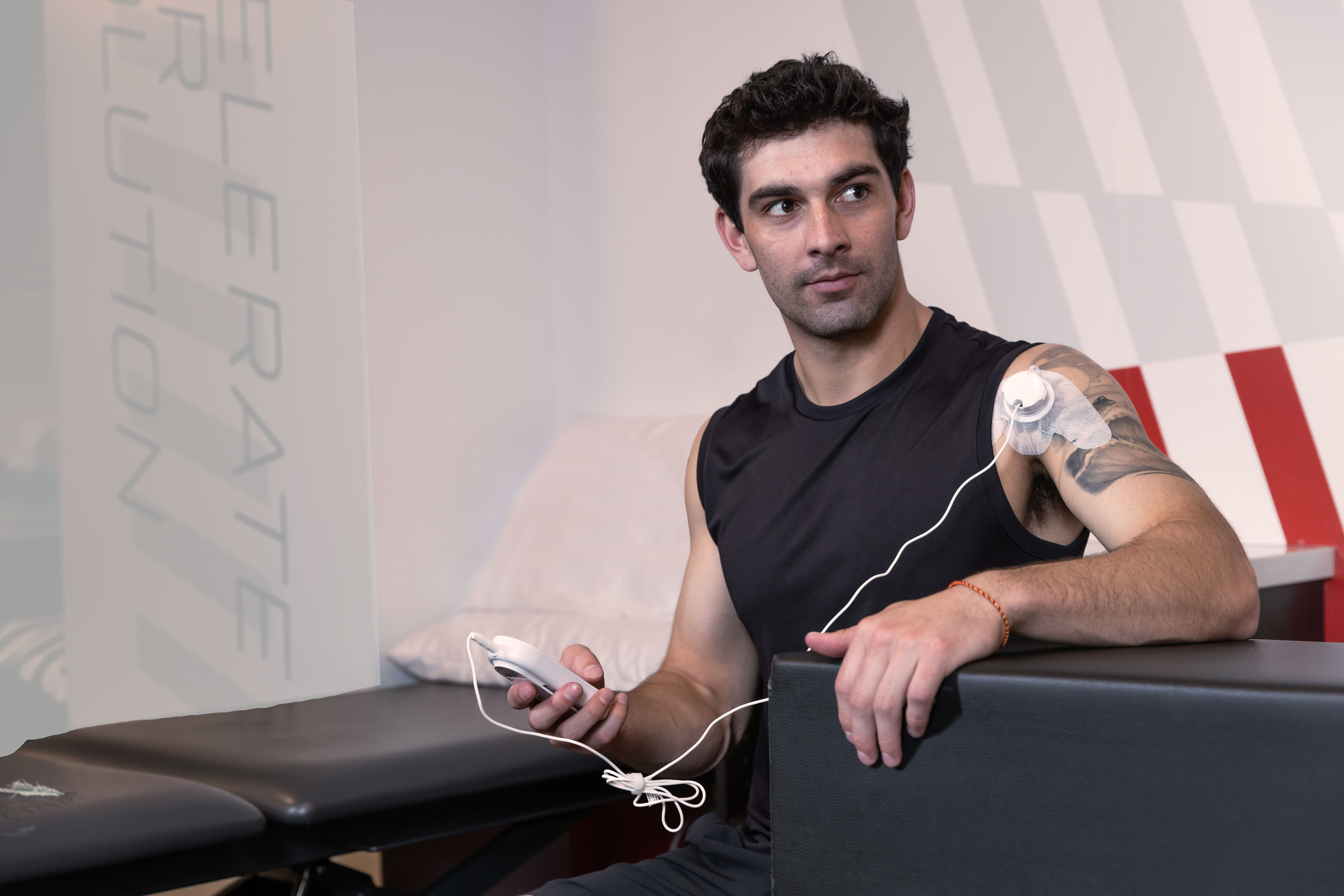 An athlete holding a ManaSport+ ultrasound unit.