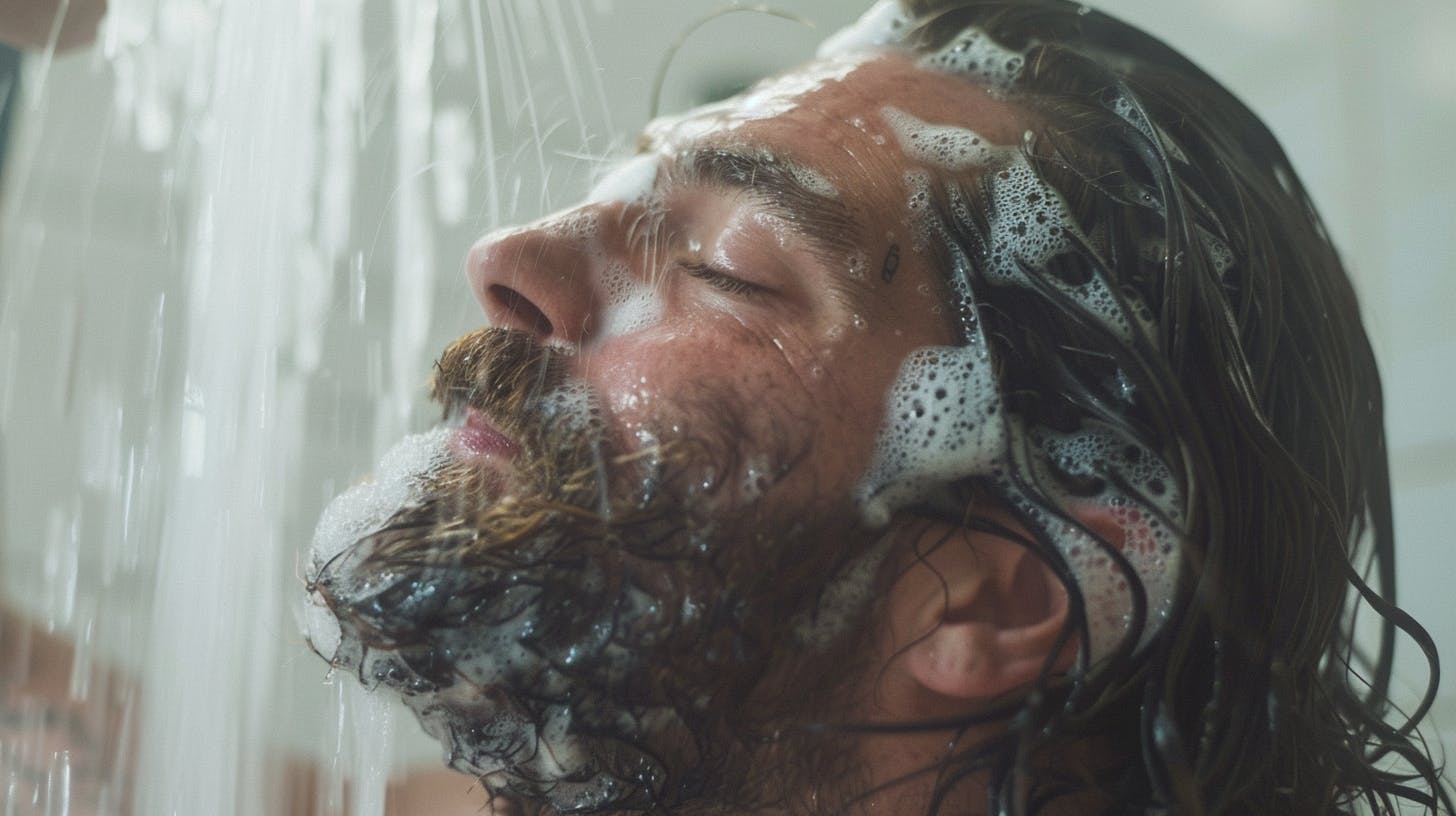 A man shampooing his beard.