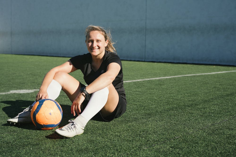women's soccer player sitting on the turf