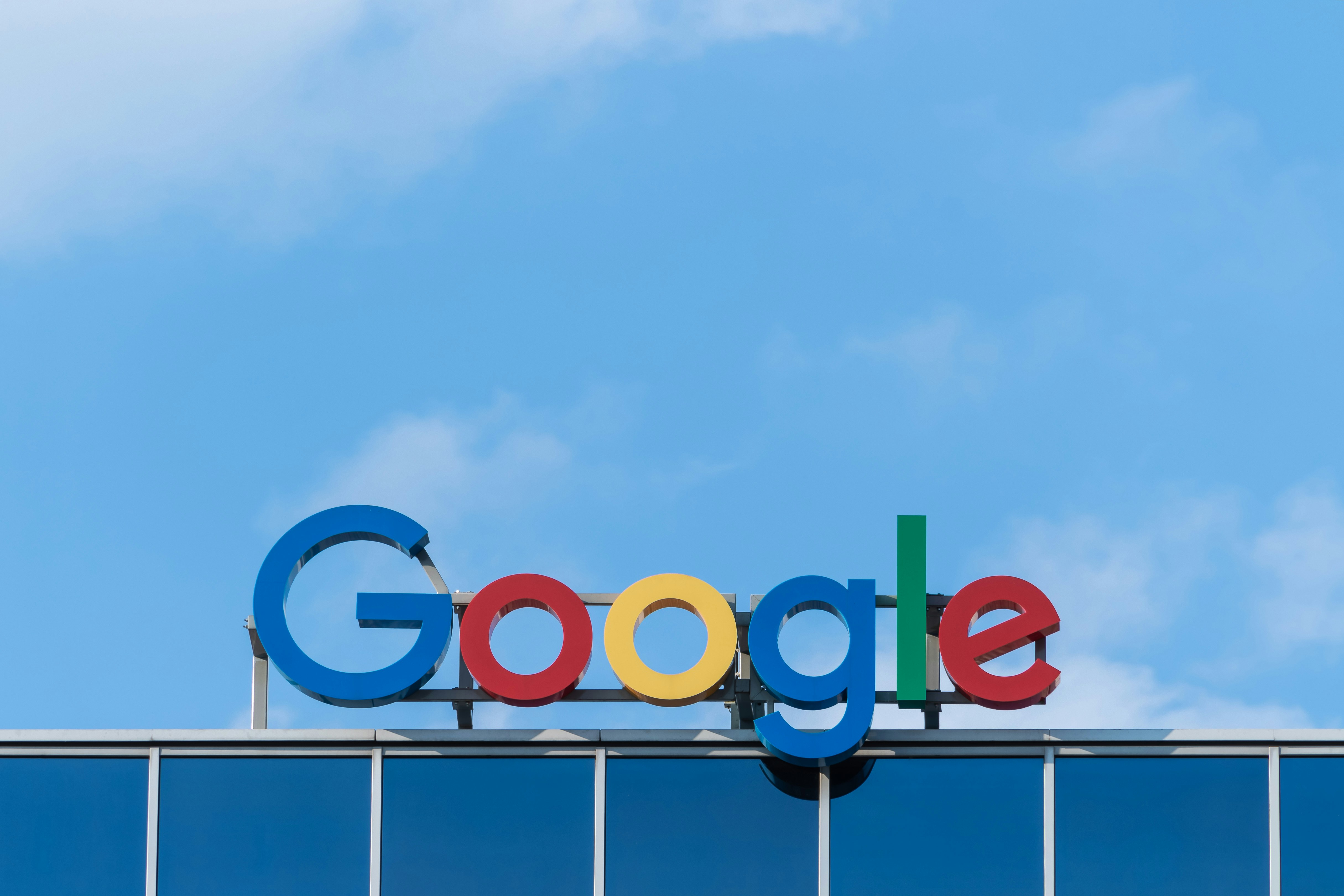 Logo Google sur le toit d'un immeuble de bureaux, sous un ciel bleu