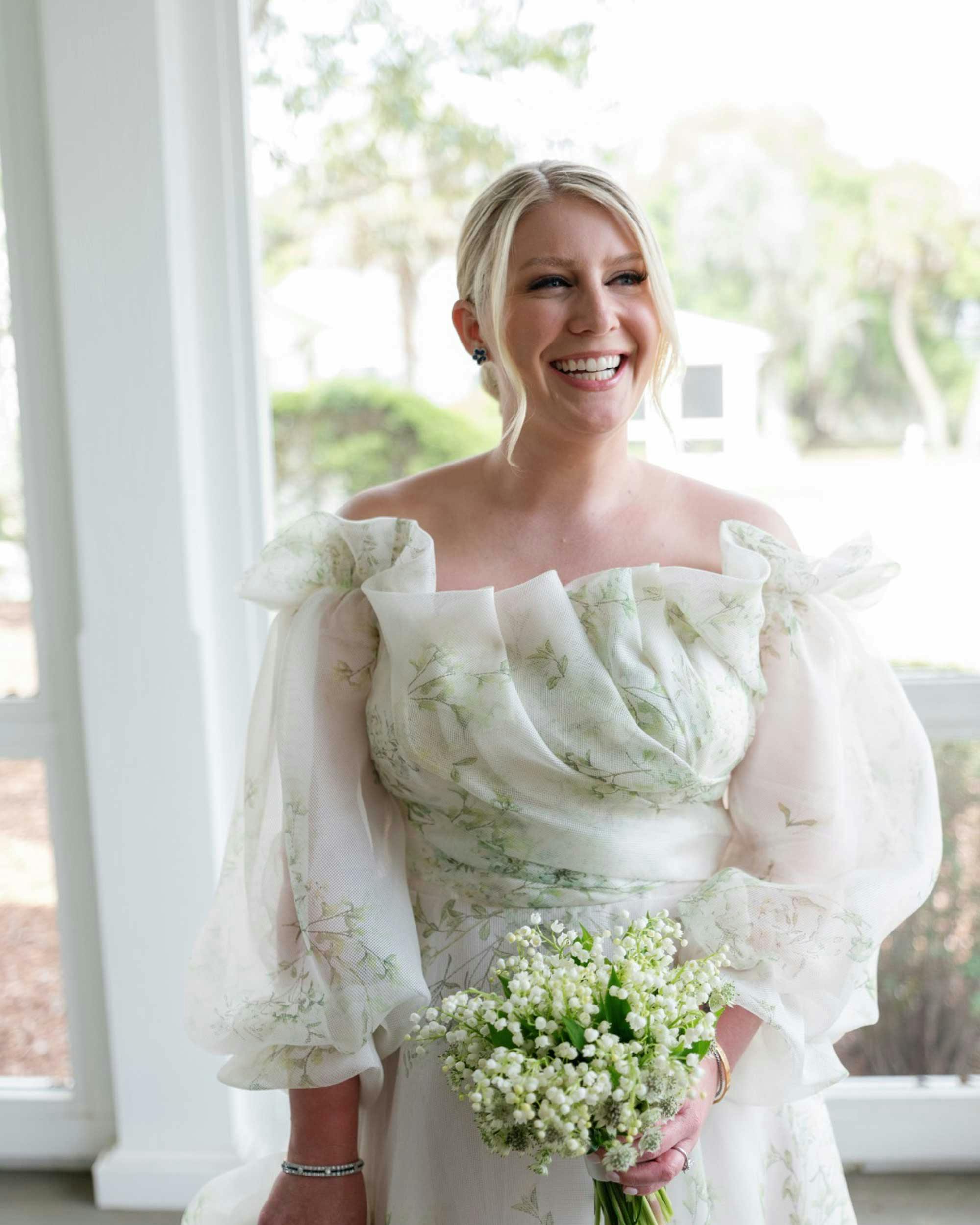 beautiful bride smiling looking away from the camera while holding flower bouquet