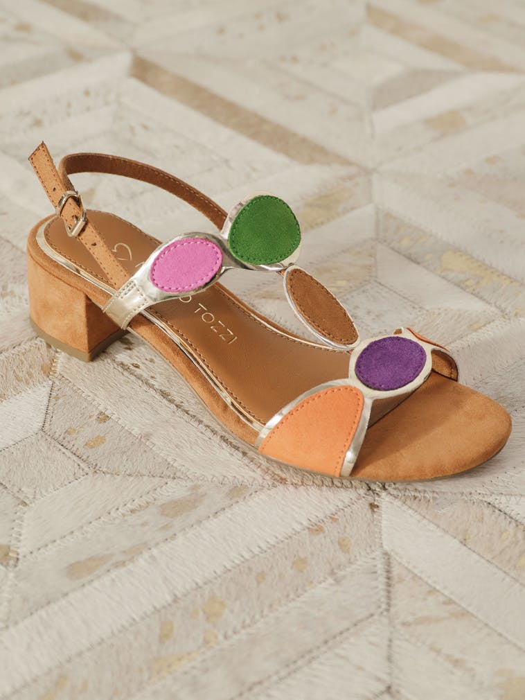 Sandals with block heels and colourful round appliqués on a light background.