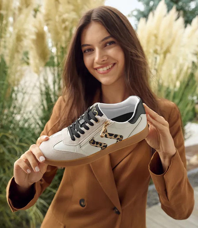 Donna con una scarpa da ginnastica con motivo leopardato